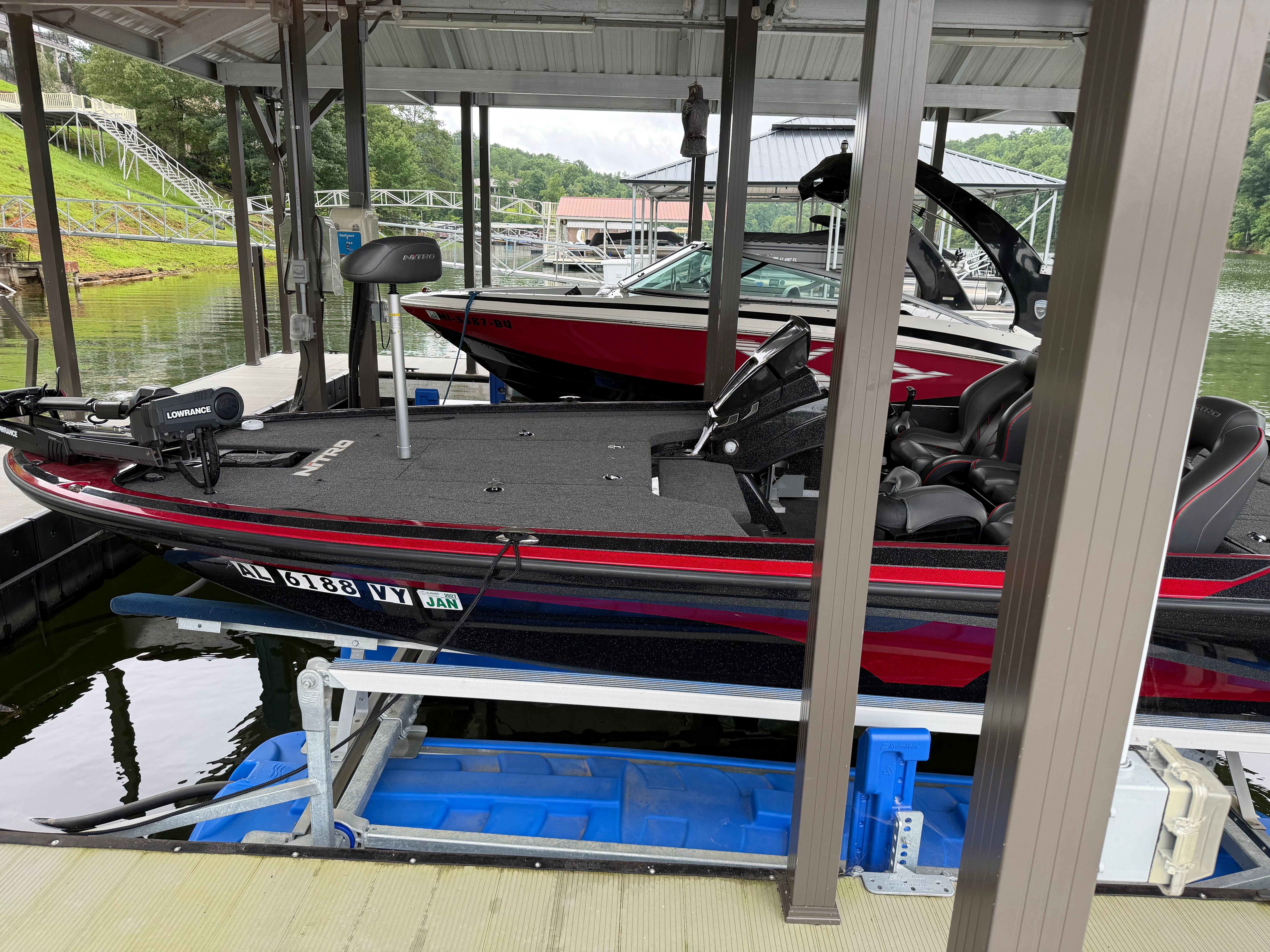 A 2024 Tracker Z19 boat is docked under a covered area on the water.
