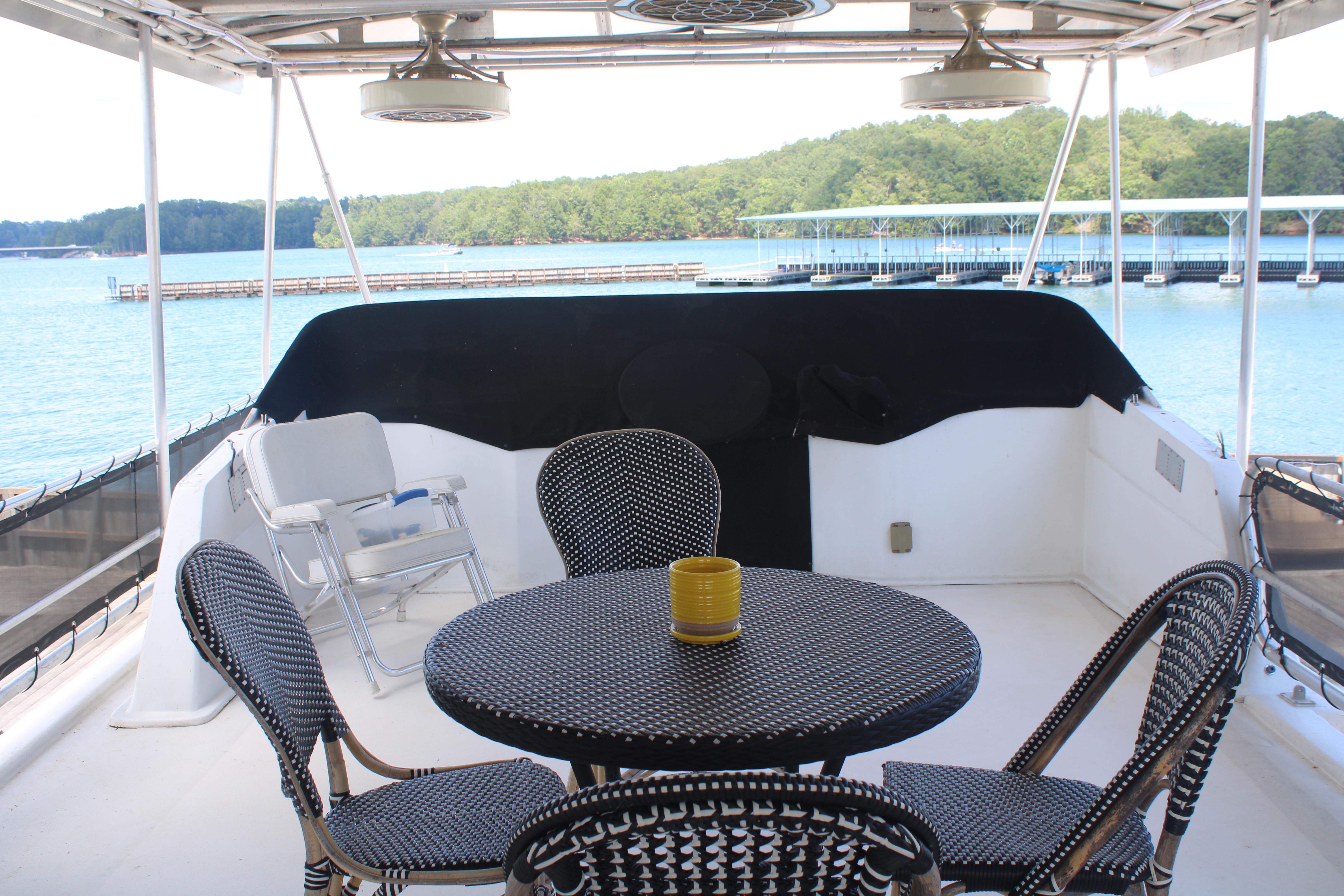 Outdoor seating on a 1992 Sumerset 66 houseboat with lake view.