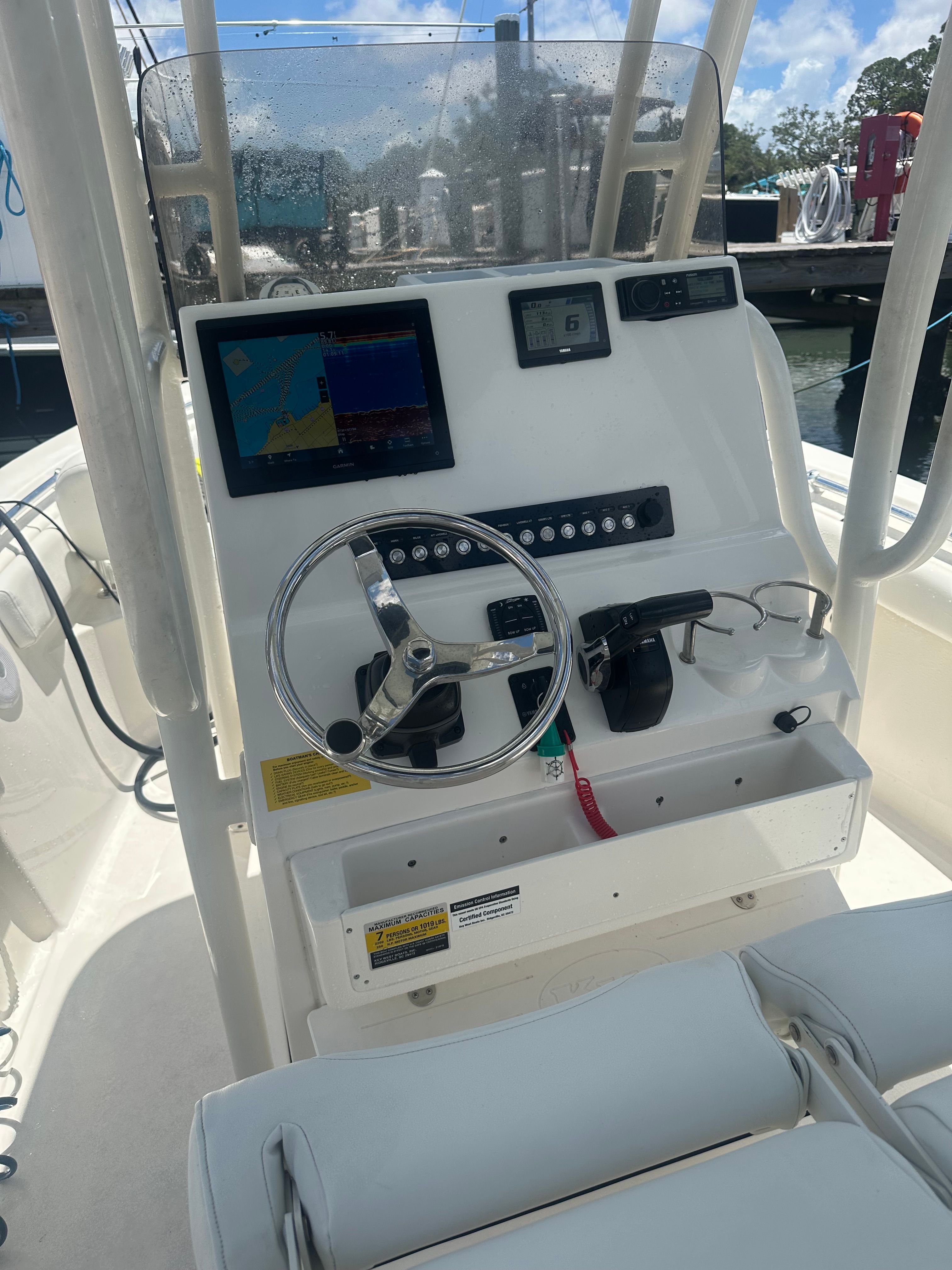 The helm of a modern boat with steering wheel and instruments.