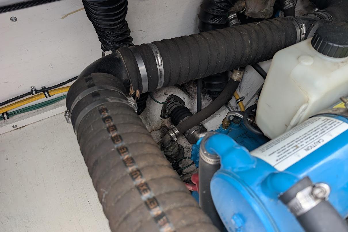 Engine compartment of a 2000 Pursuit 3400 Express boat, showing hoses and components.