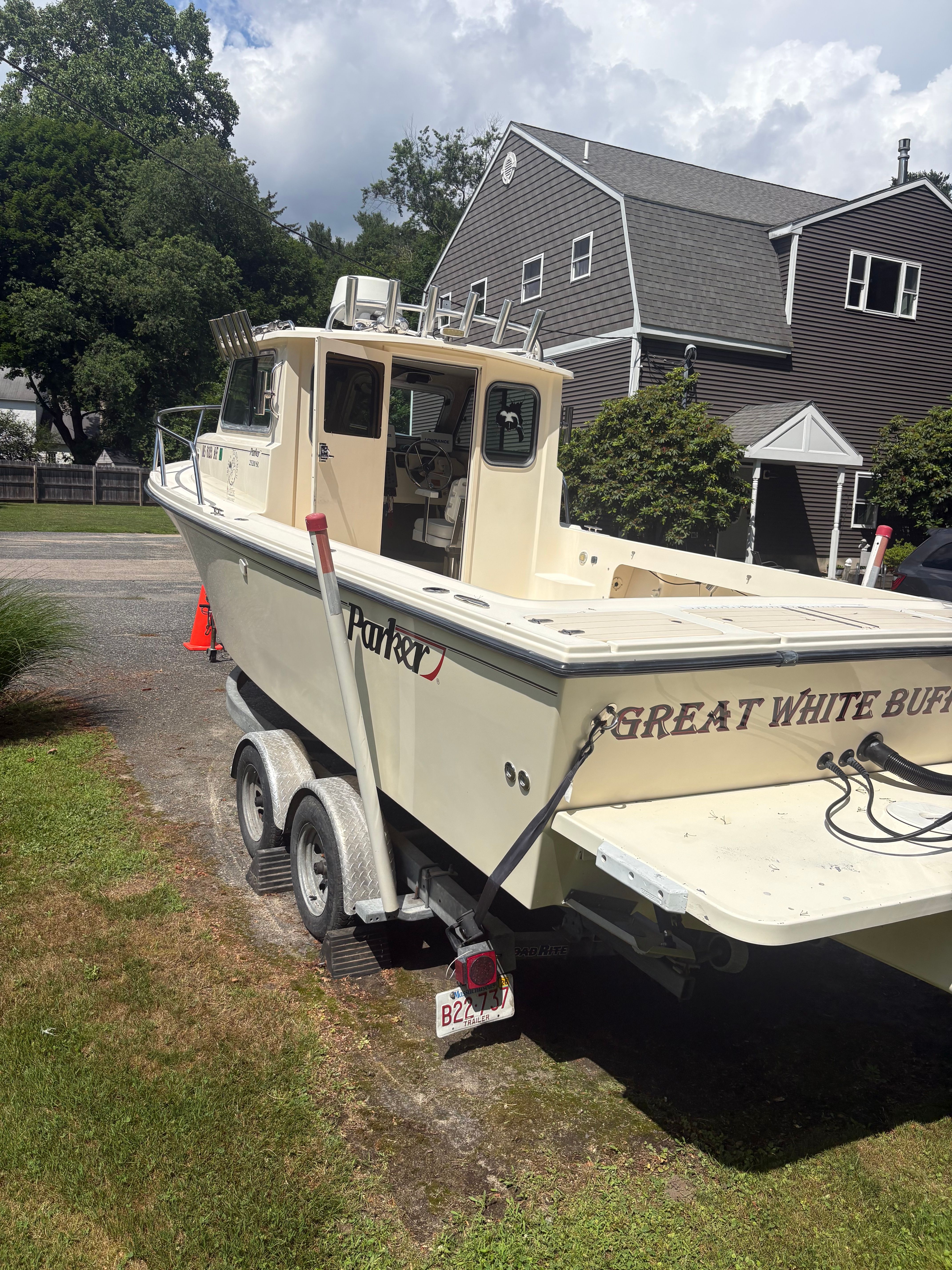 2009 Parker 2320 Sport Cab on a trailer in a residential area.