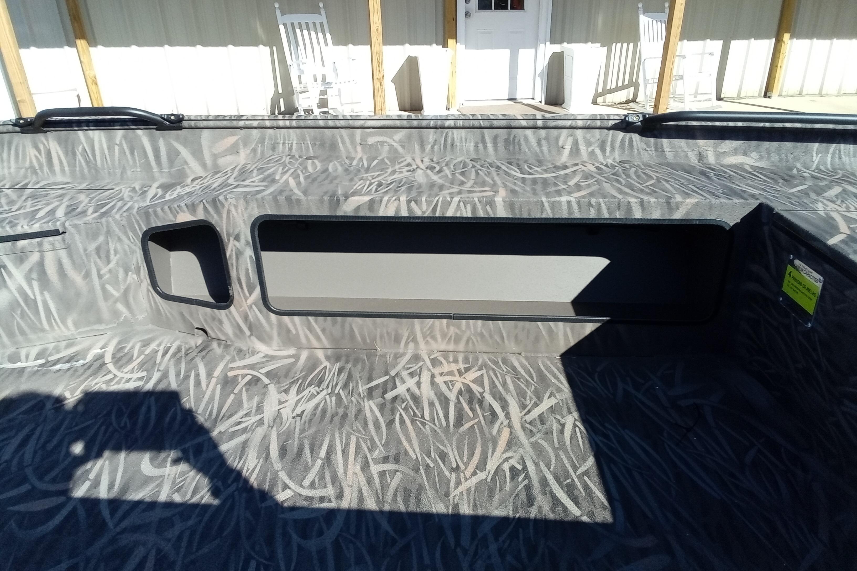 2026 Alweld 1652 Invader boat interior with camouflage pattern and storage compartments.
