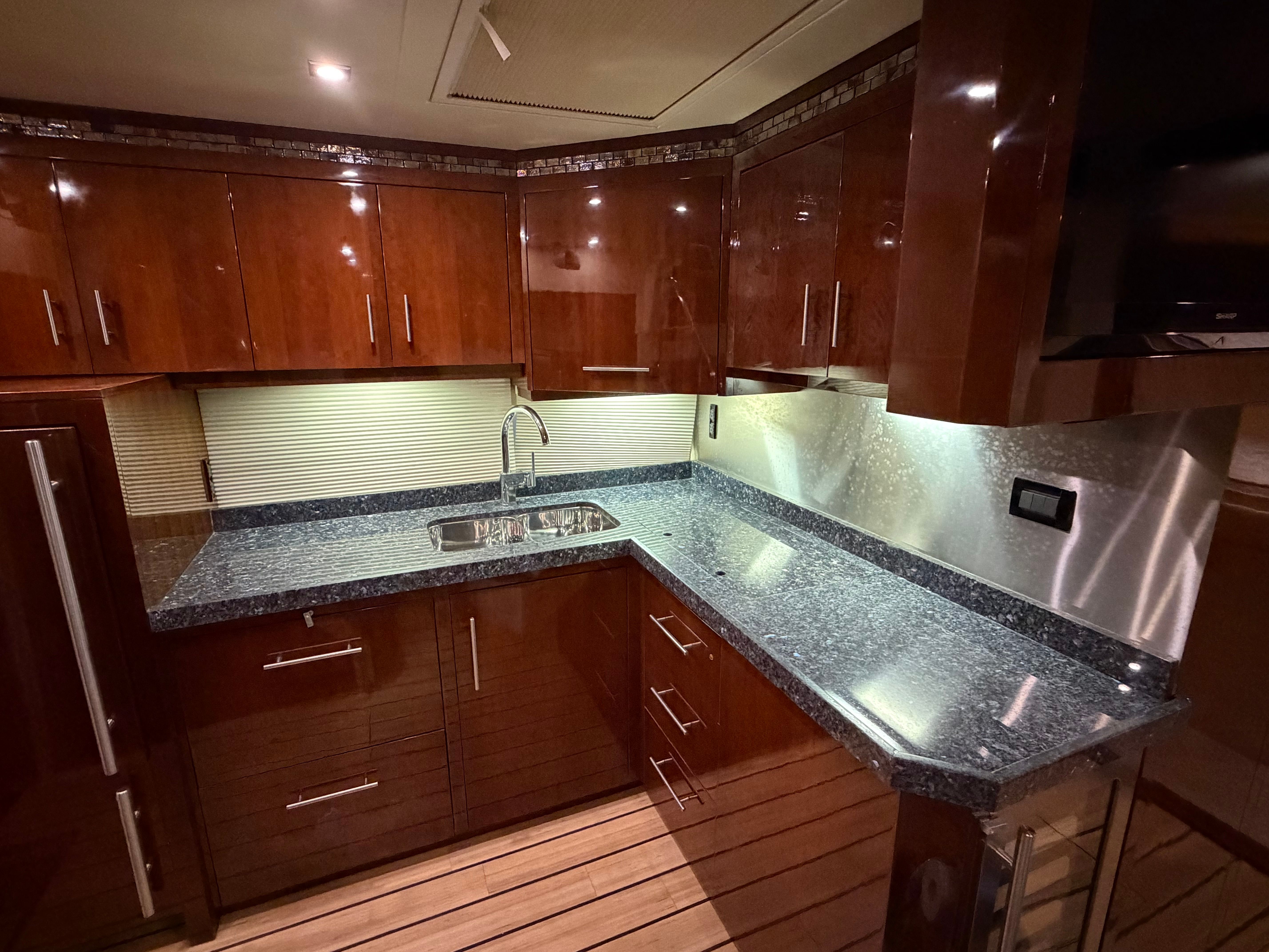 Luxurious kitchen interior of 2014 Regal 52 Sport Coupe yacht with sleek countertops.