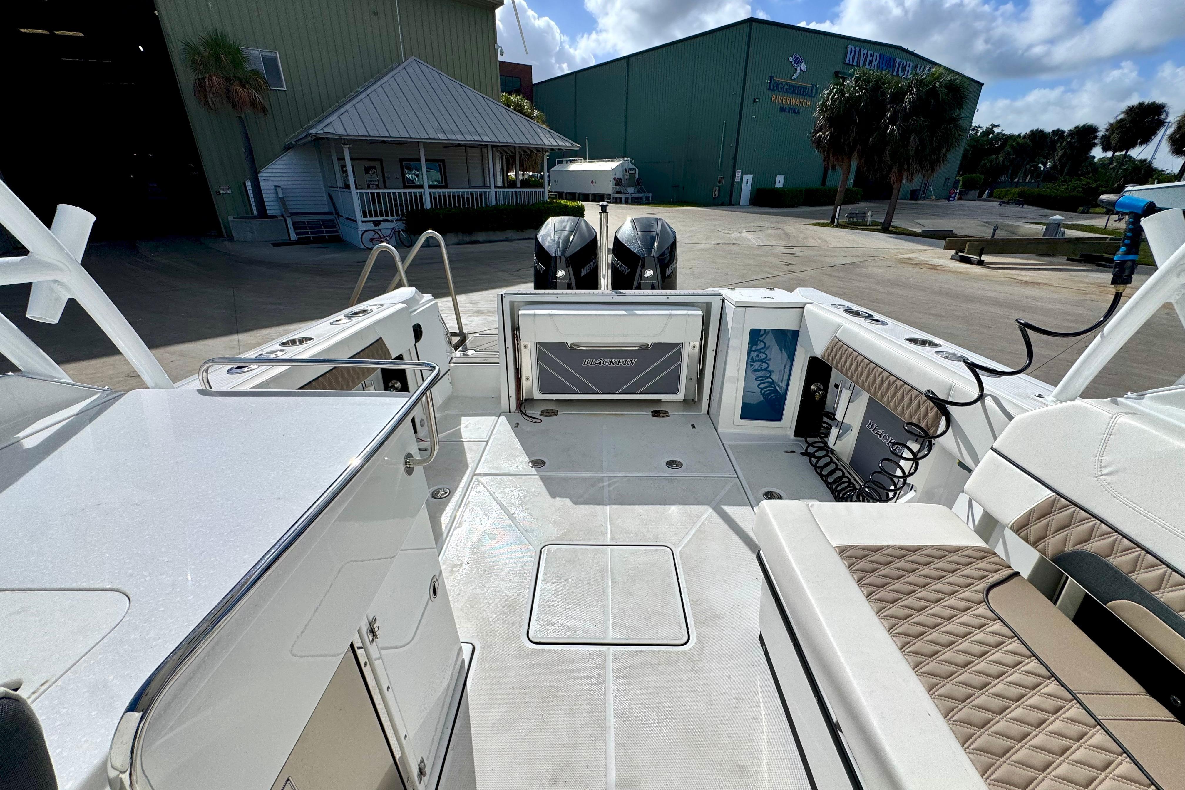 2023 Blackfin 272 DC boat interior with seating and storage, docked near a marina.