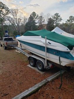 1996 Wellcraft 2400S boat on trailer, covered, parked outdoors.
