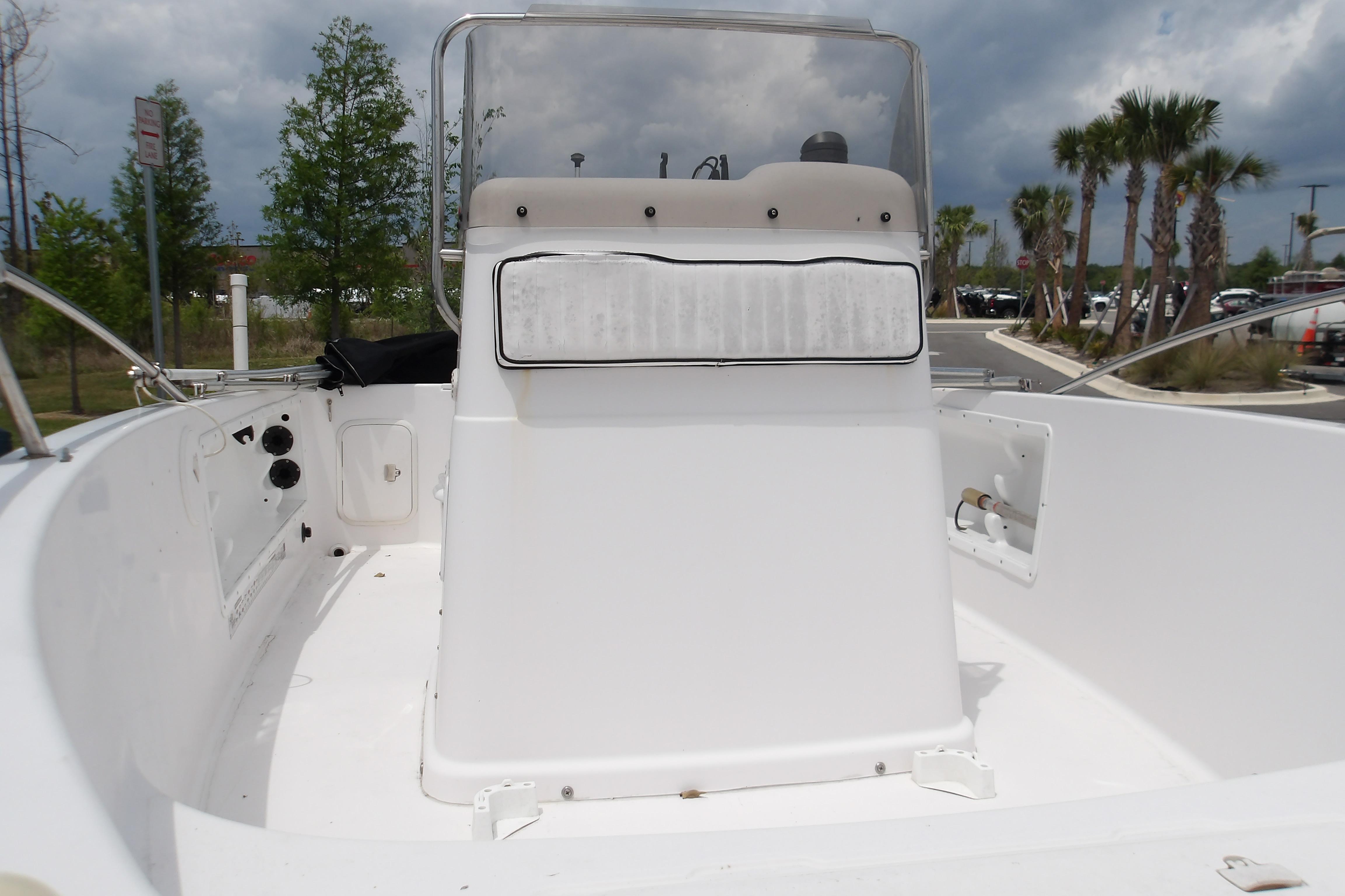 2000 Pro-Line 19 Sport boat interior with console, set against a cloudy sky and palm trees.