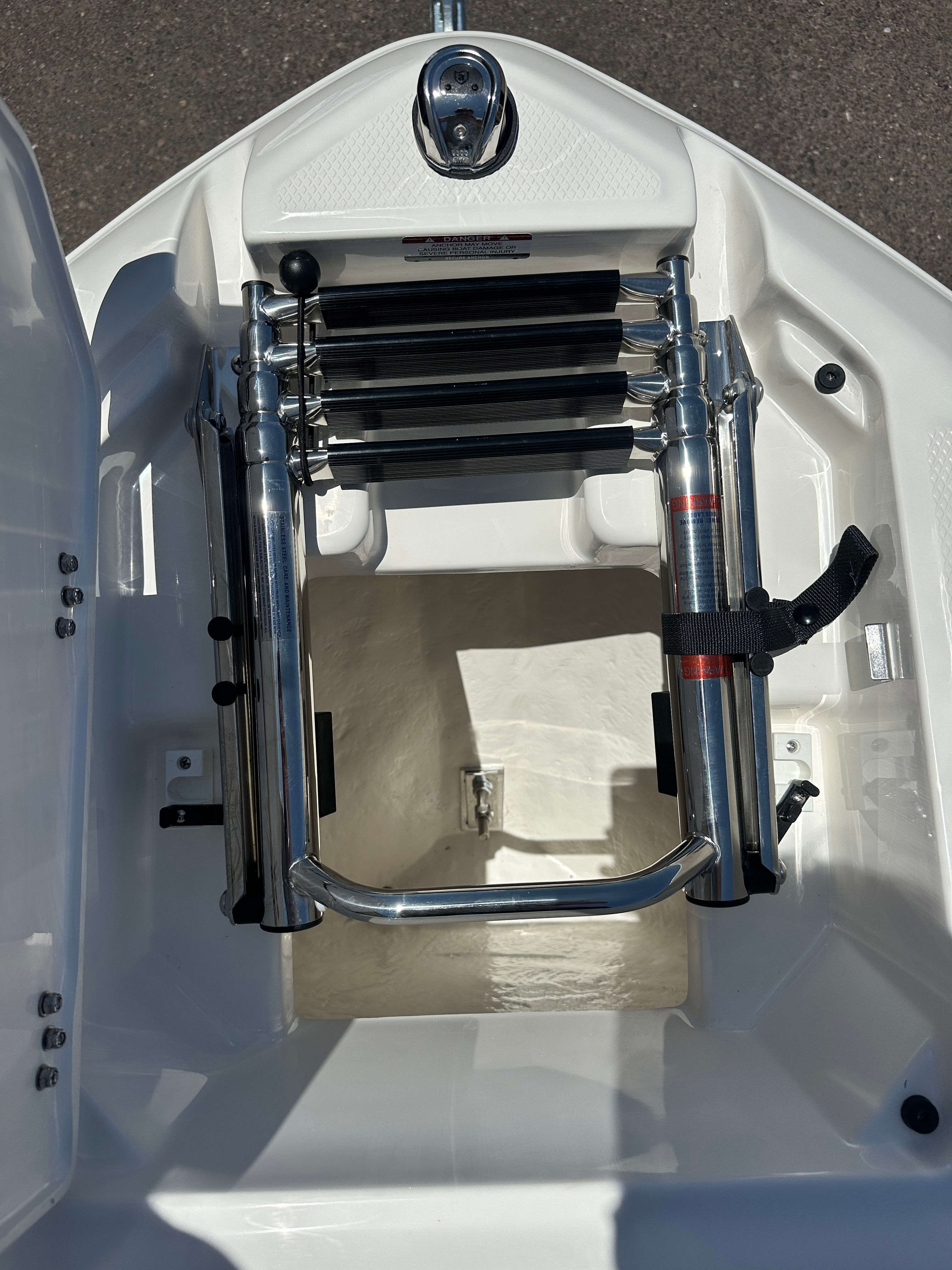 A stainless steel boat ladder is installed in a white boat.
