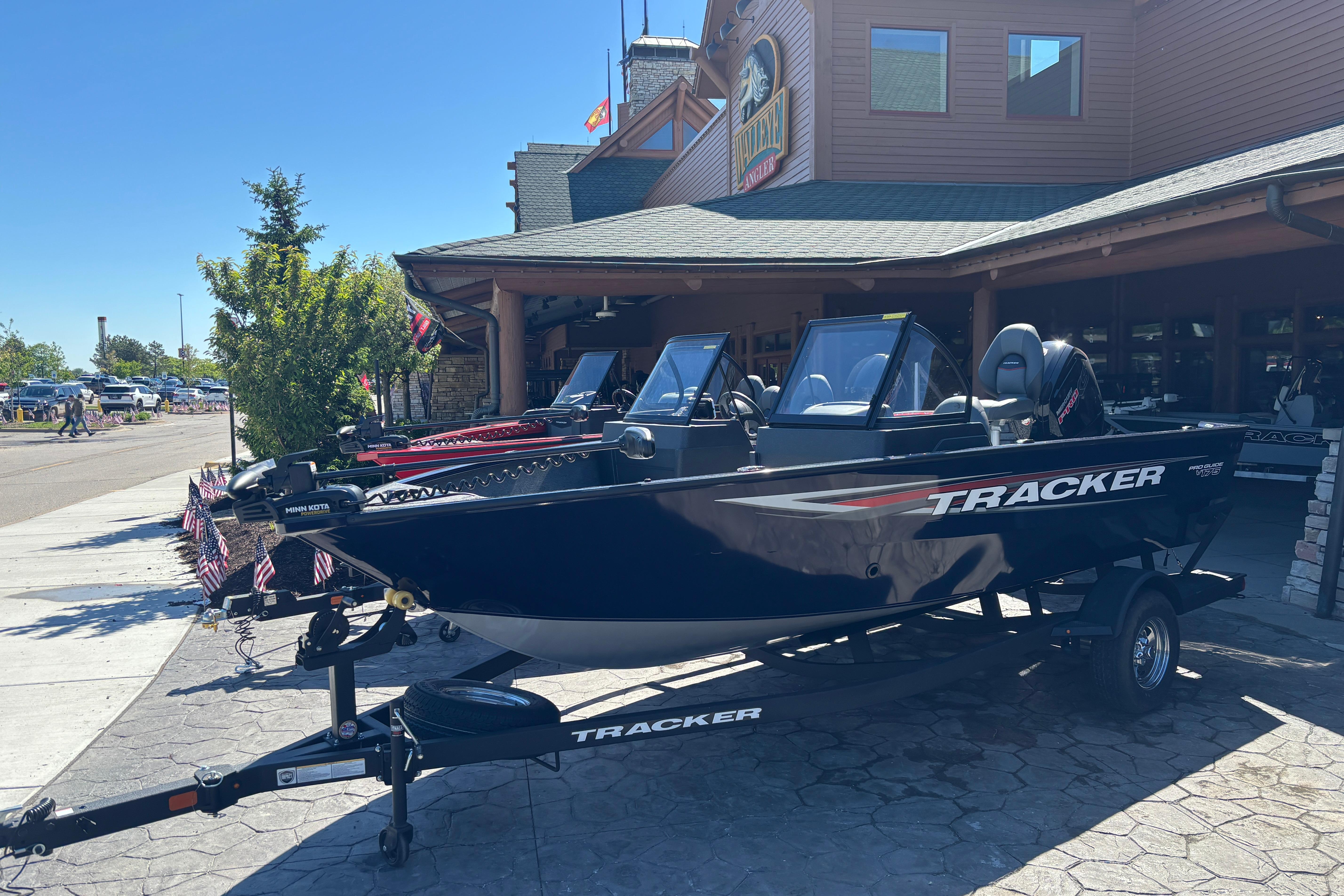2026 Tracker Pro Guide V-175 WT boat displayed outside a wooden building.