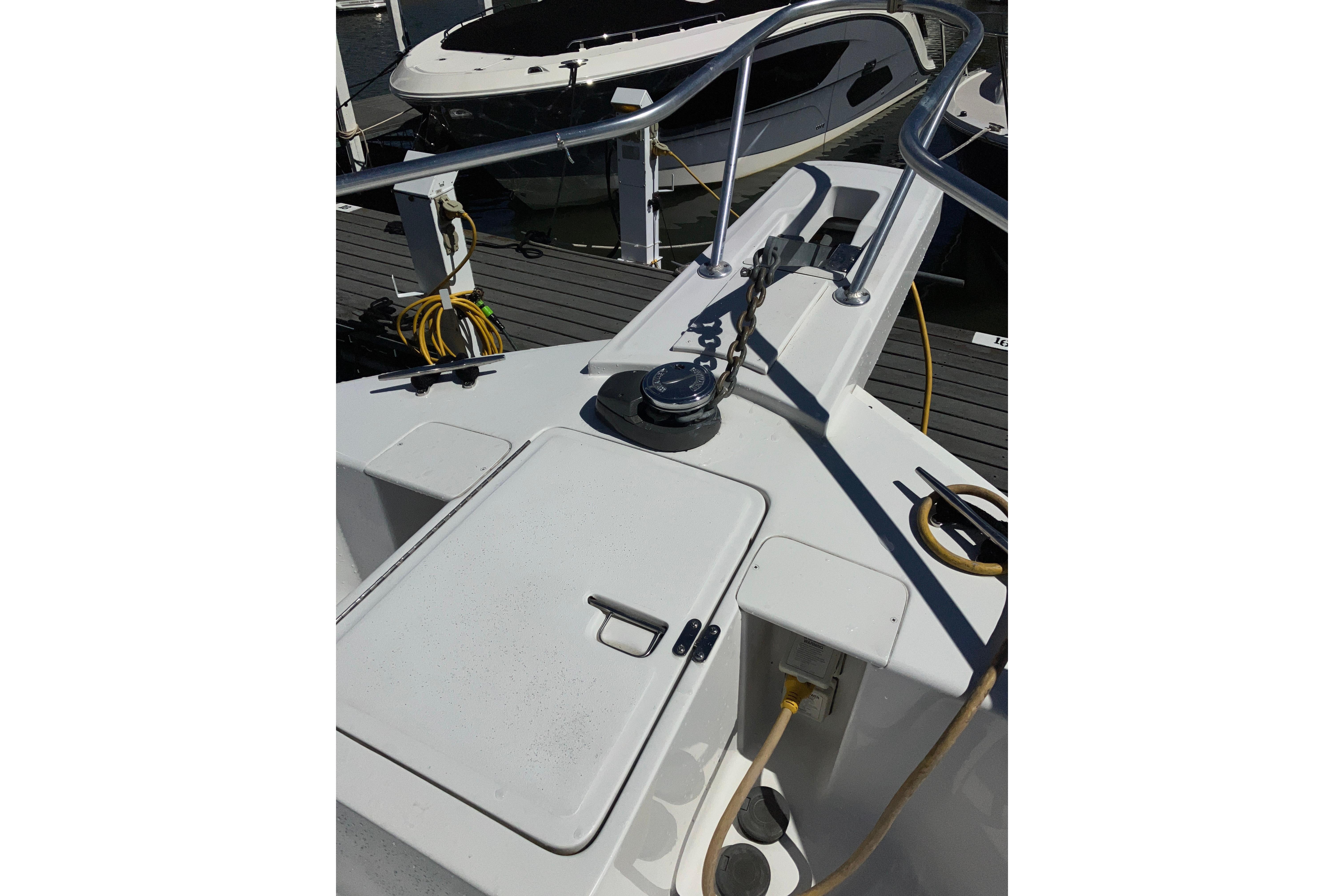 1999 Mainship 350 Trawler deck with railing, docked at marina.