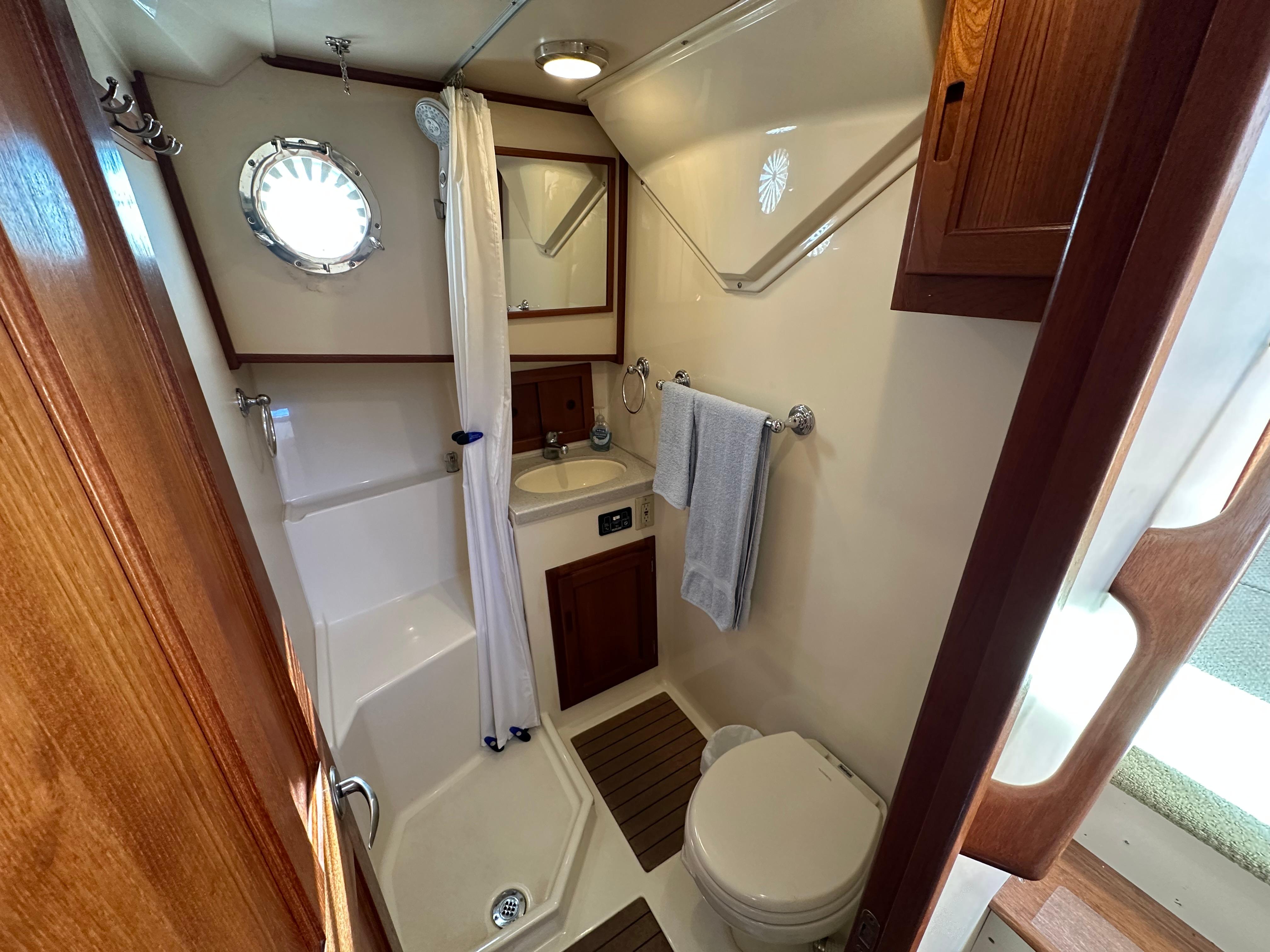 2007 Nordic Tug 32 bathroom with shower, sink, and wooden accents.