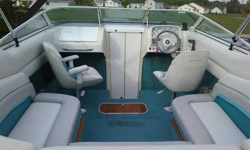 Interior view of a 1993 Chris-Craft 238 Cuddy Concept with white seats and blue carpet.