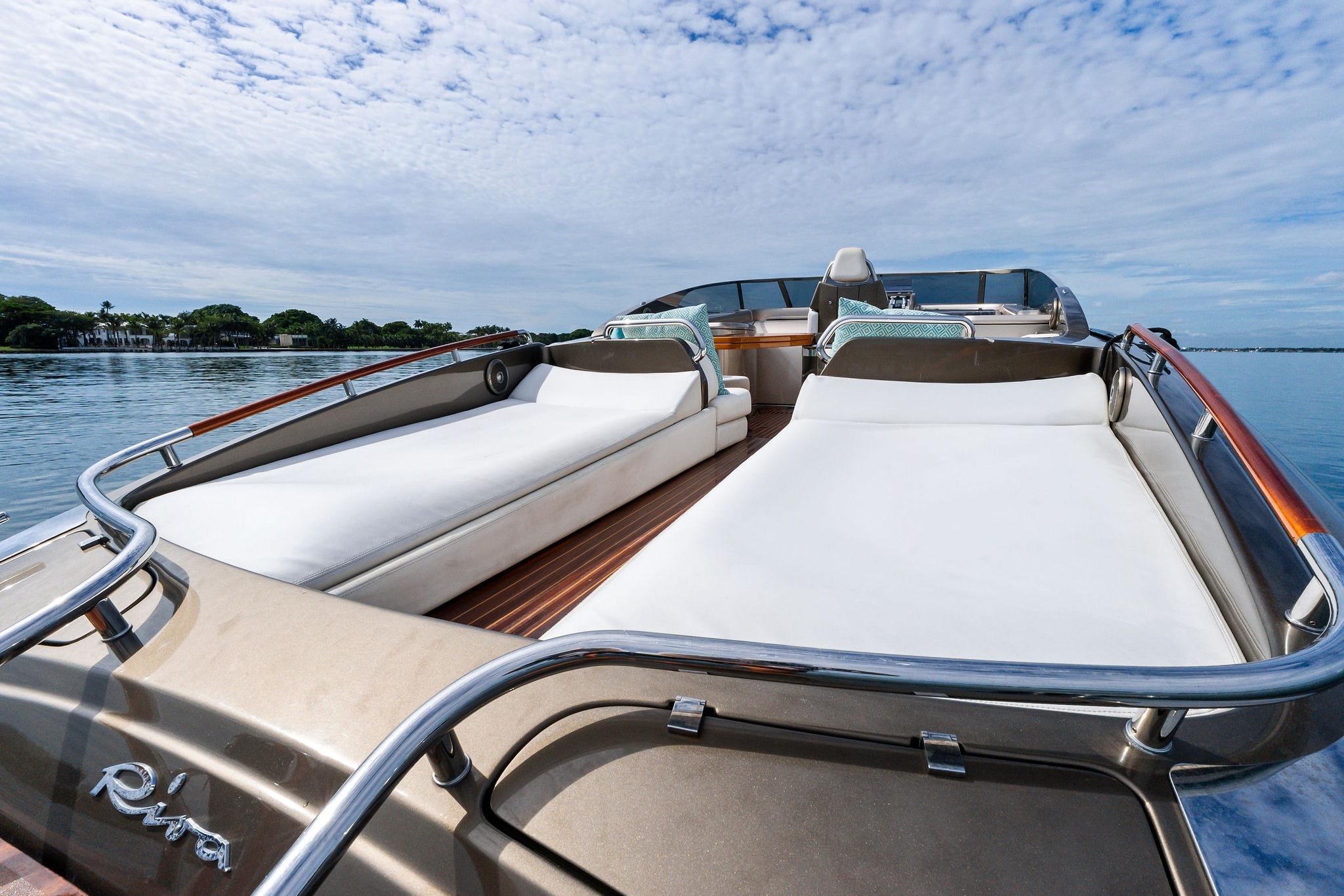 Luxurious 2014 Riva Rivarama yacht with spacious sunbeds on calm water.