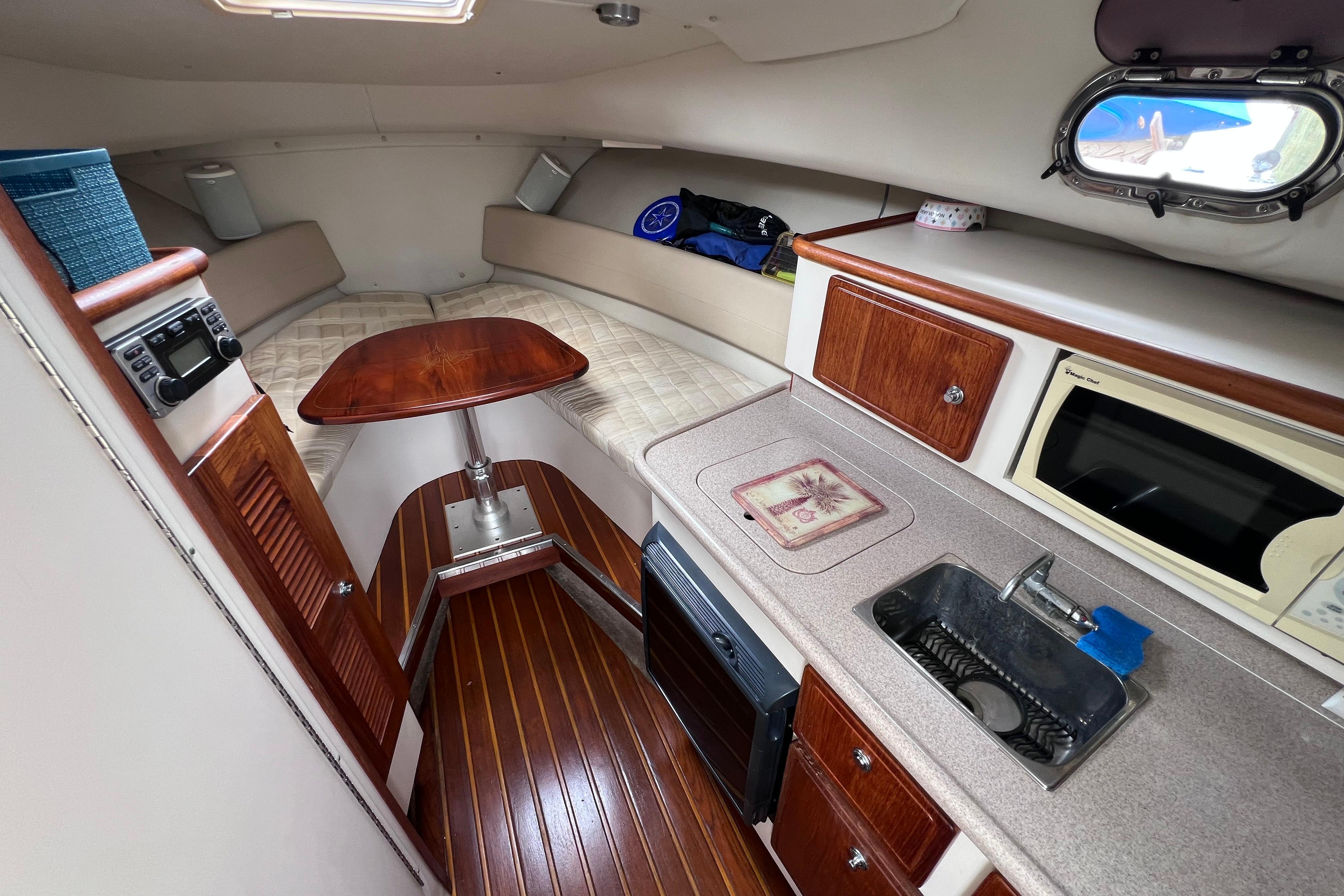 Interior of a 2005 Pursuit 3070 Offshore boat with kitchenette and seating area.
