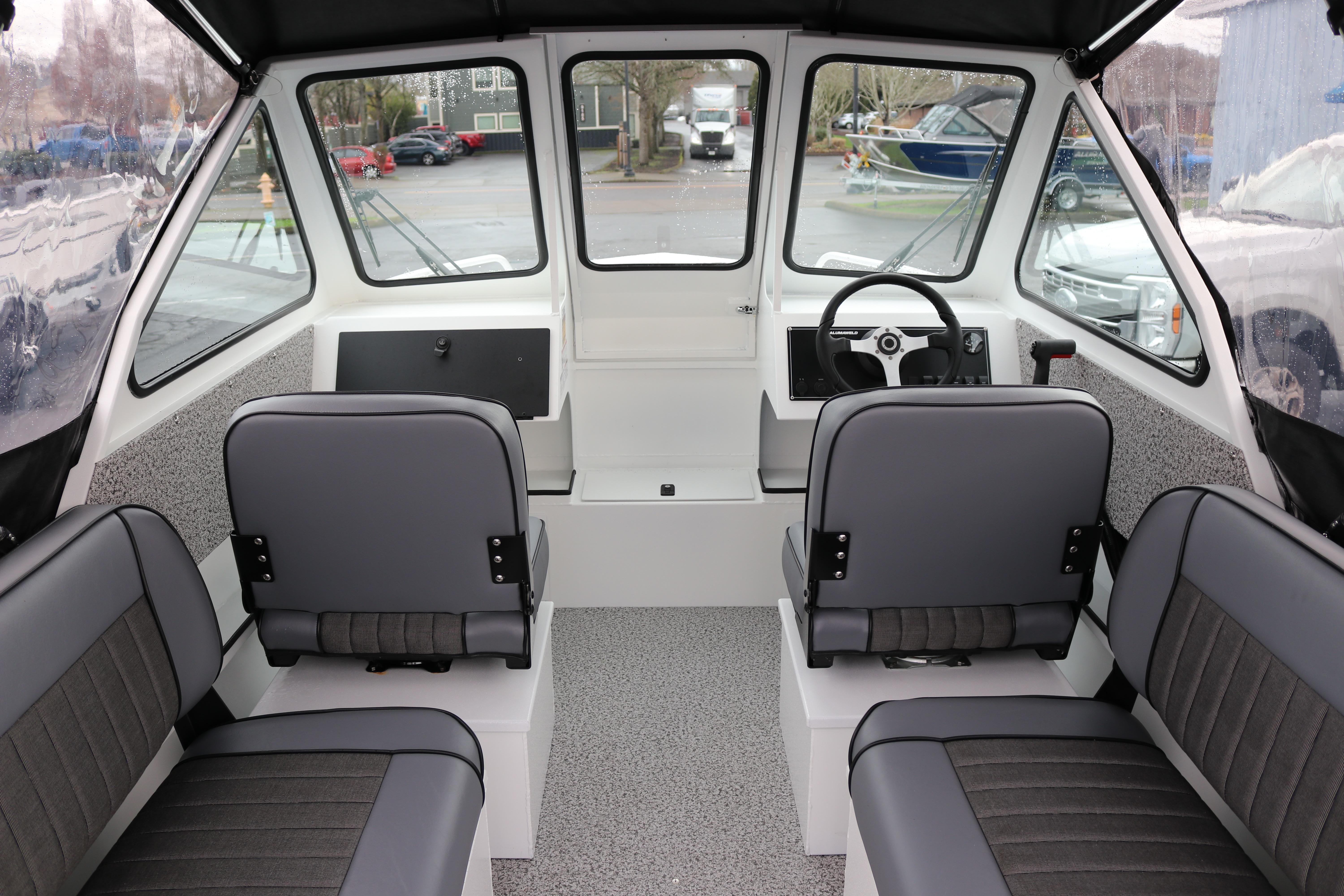 Interior of 2026 Alumaweld Stryker 202 boat with gray seating and steering wheel.