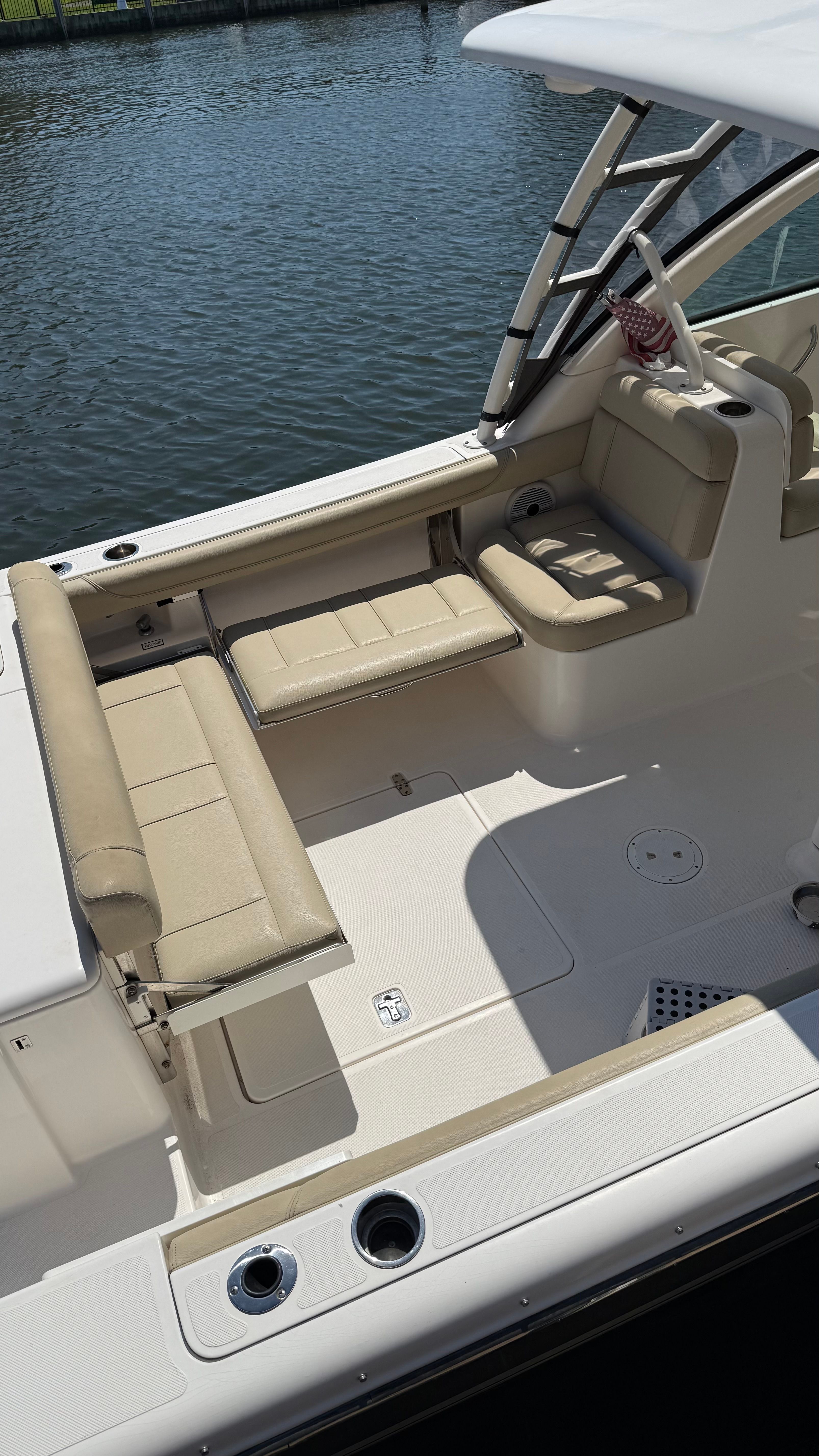 A 2016 Pursuit DC 265 Dual Console with beige seating and a clean, open deck.