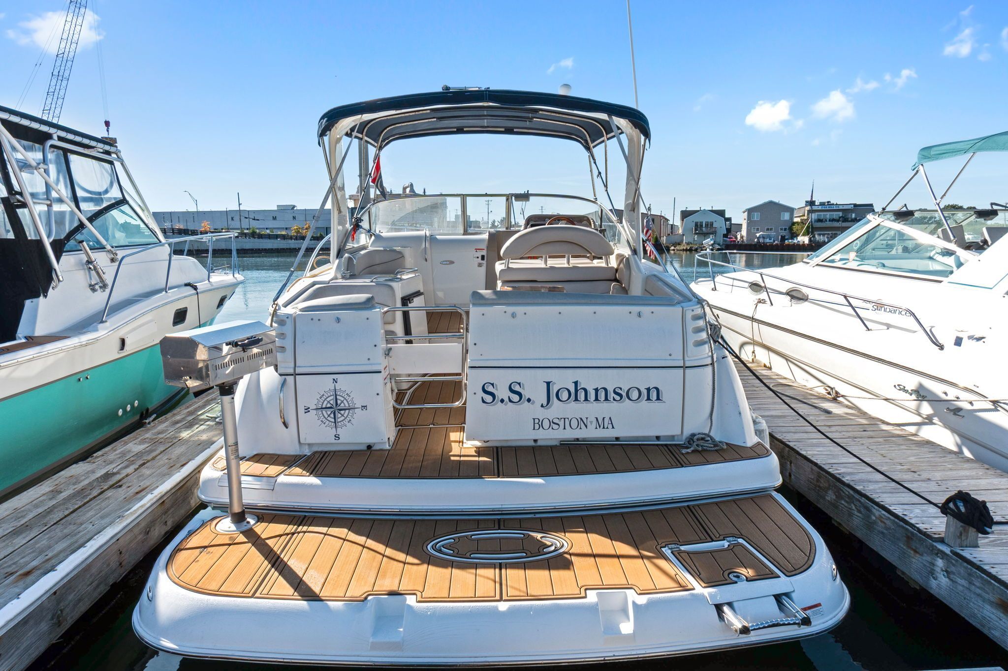 The image shows a 2007 Larson Cabrio 330 boat docked. It features an open cockpit and wooden deck.