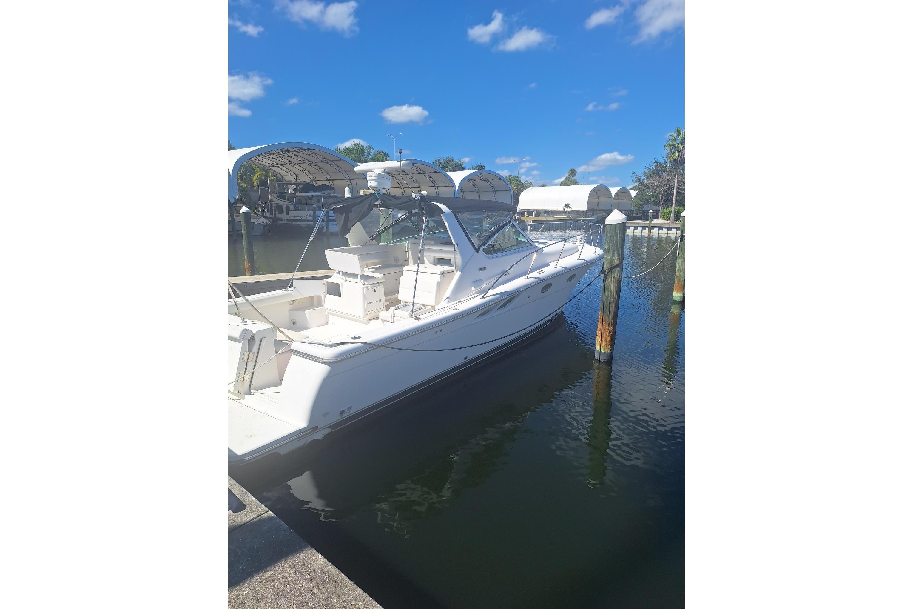 2002 Tiara 3500 Open yacht docked in a sunny marina, clear blue sky.