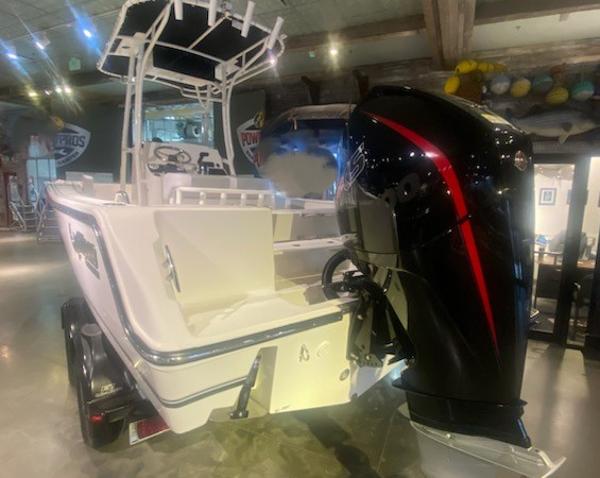 2024 Mako 214 CC center console boat with powerful outboard motor in showroom.