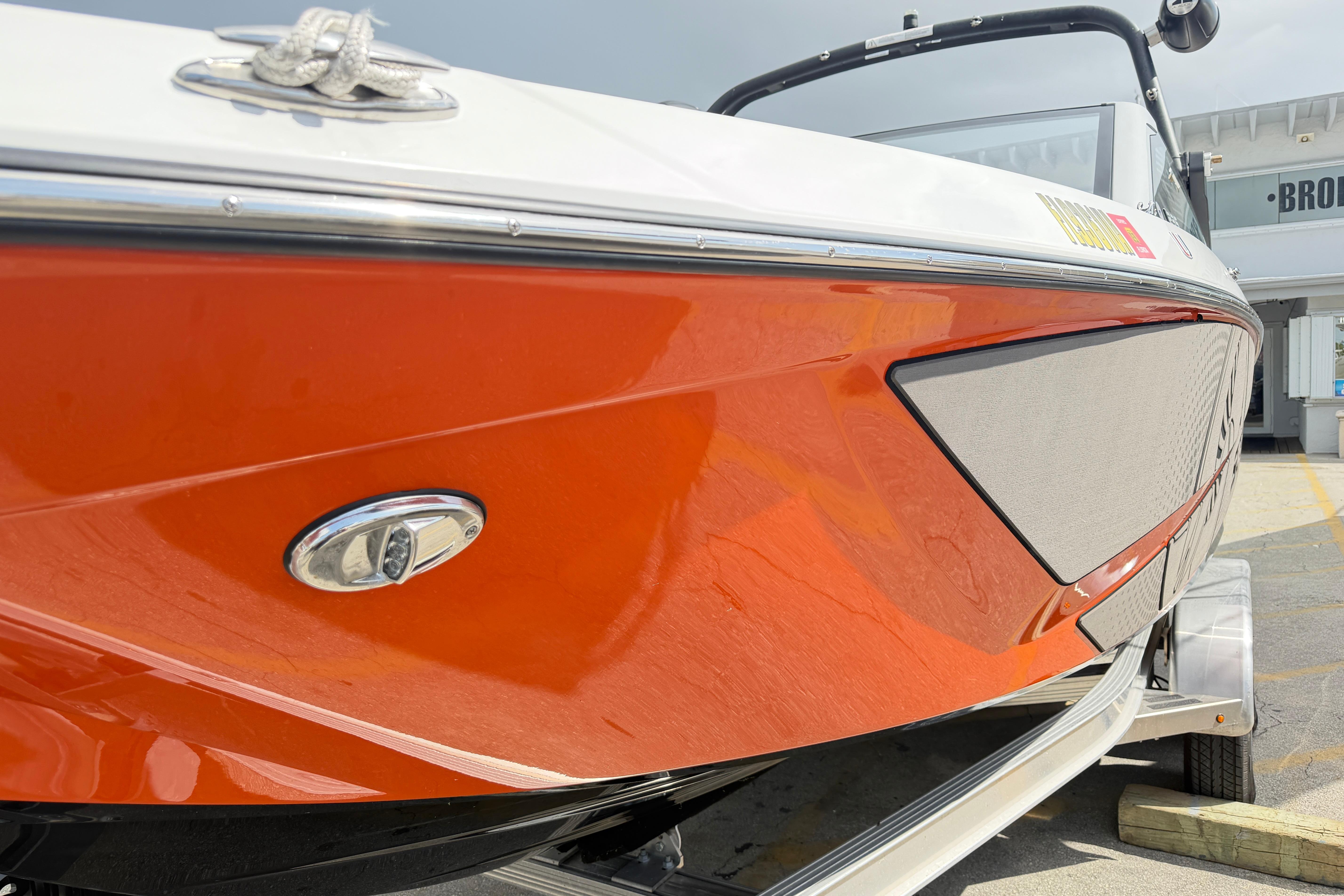 2026 Scarab 235 LX boat with sleek orange hull and modern design.