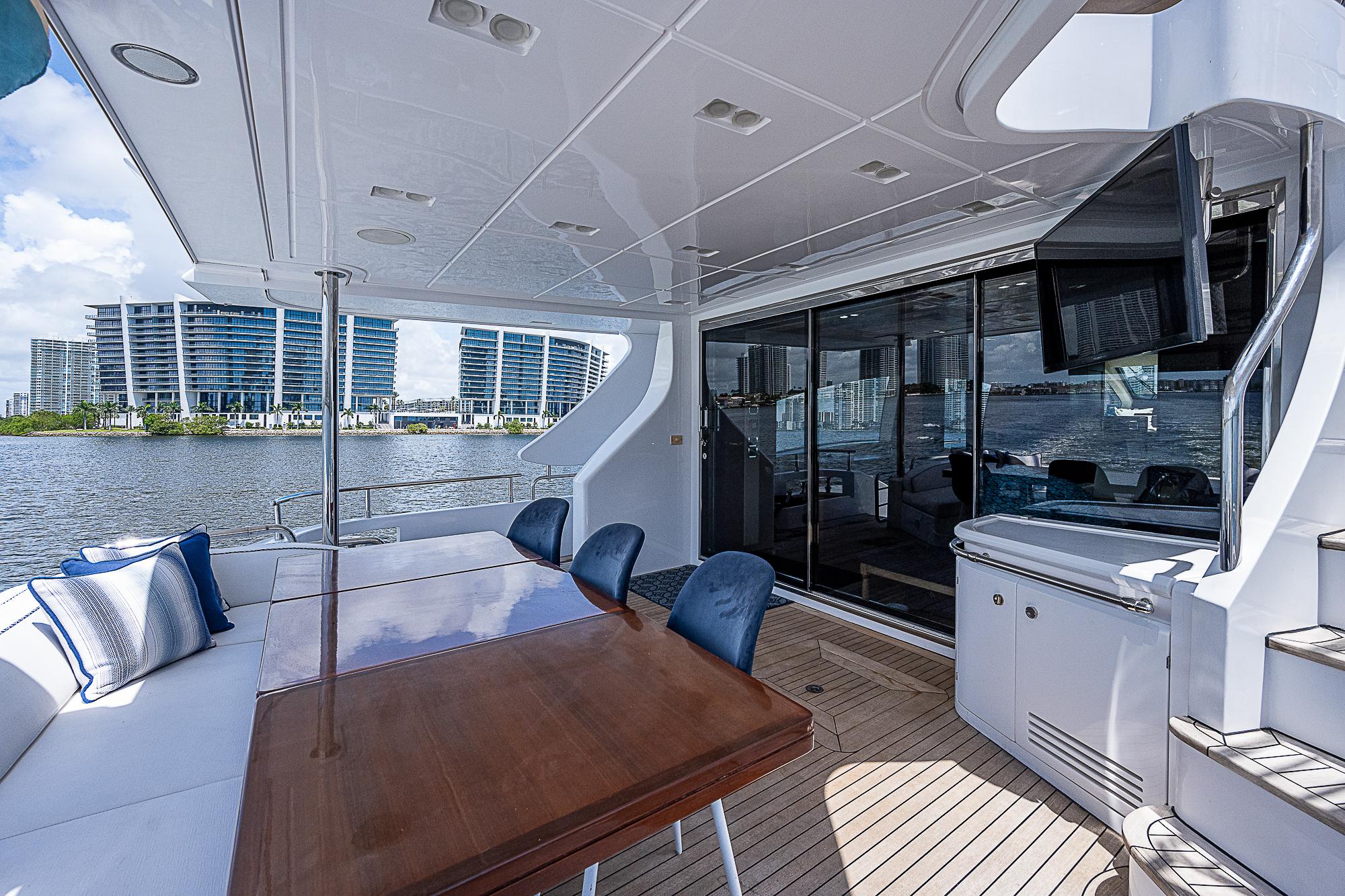 Luxurious 2011 Azimut 82 yacht deck with dining area and waterfront view.