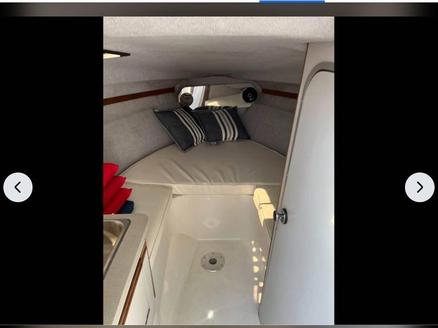 Interior of a 1990 Regal Valante 225C with bed and cushions.