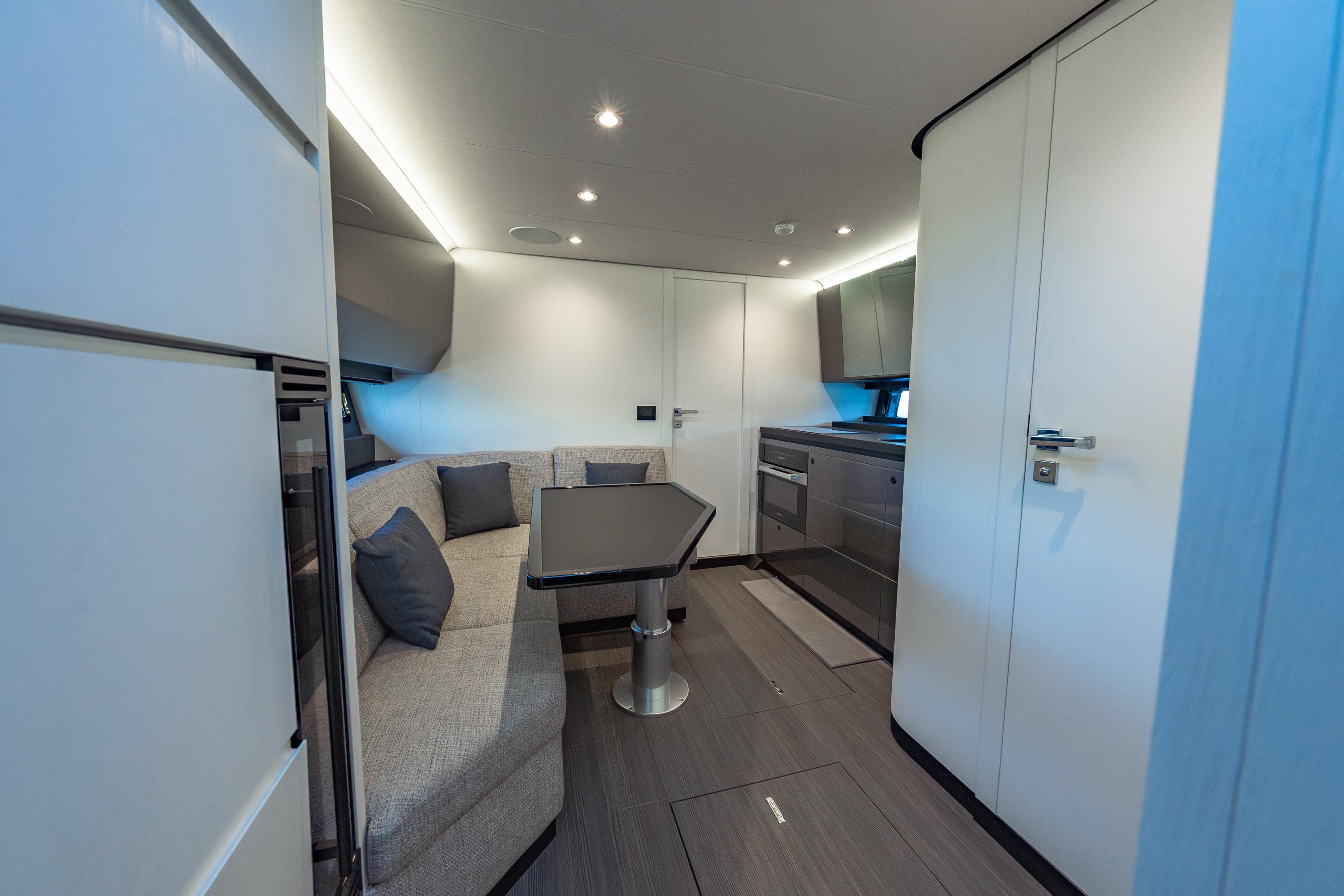 Luxurious interior of 2023 Azimut Verve 47 yacht with modern seating and kitchen area.