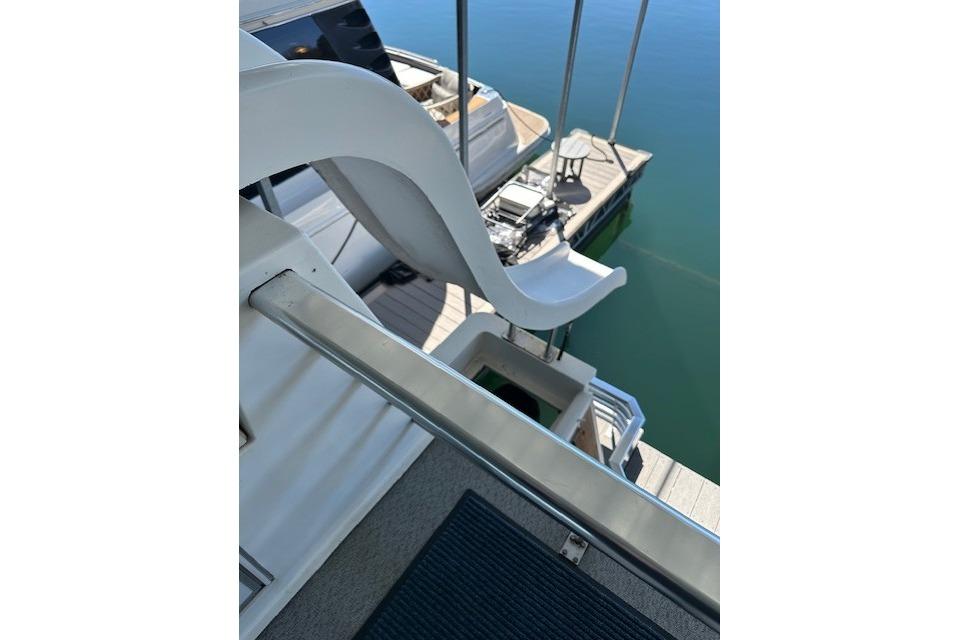 2008 Destination Yachts 45X14 with slide, docked on calm water.