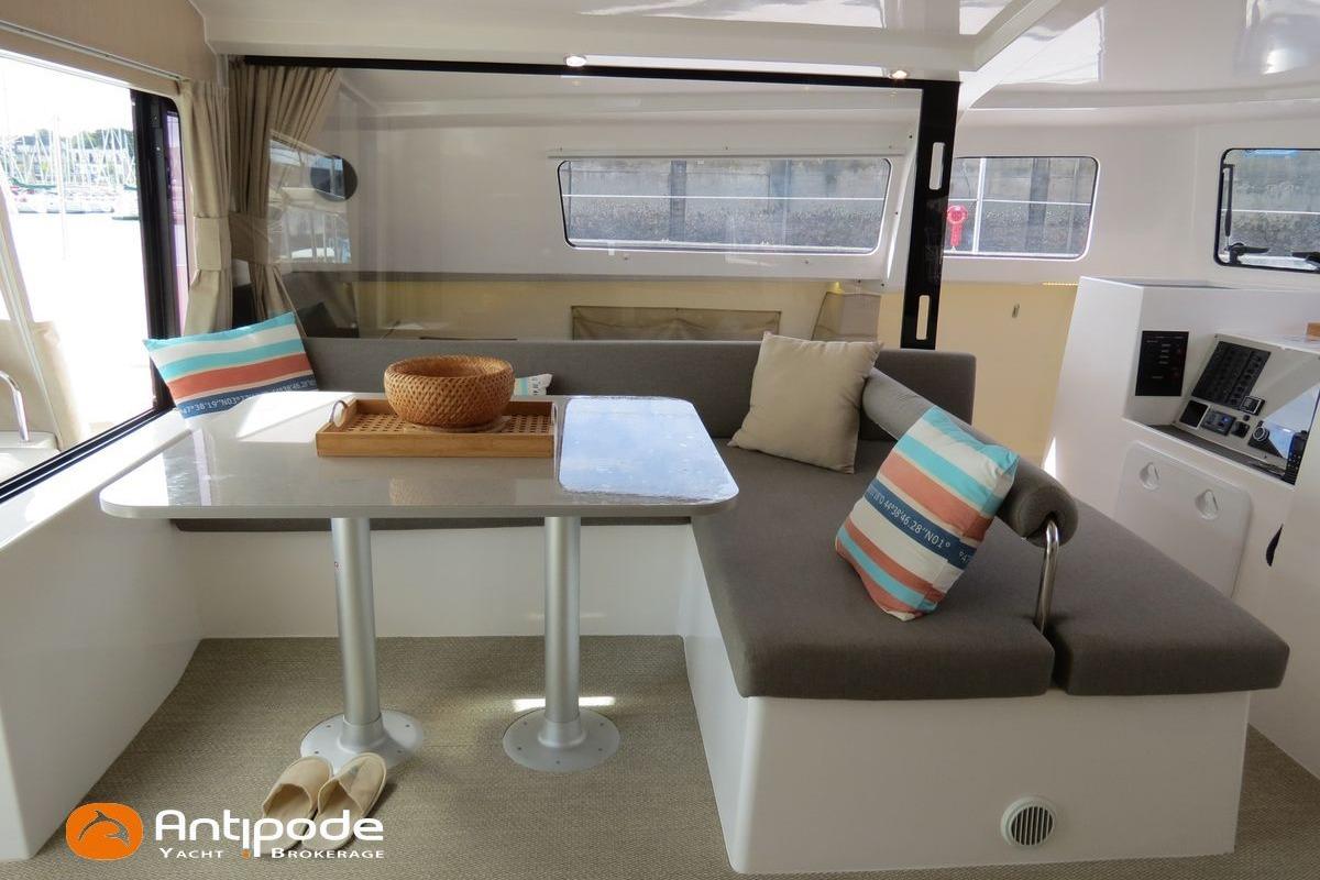Modern NEEL 43 yacht interior with cozy seating, table, and colorful cushions, 2022 model.