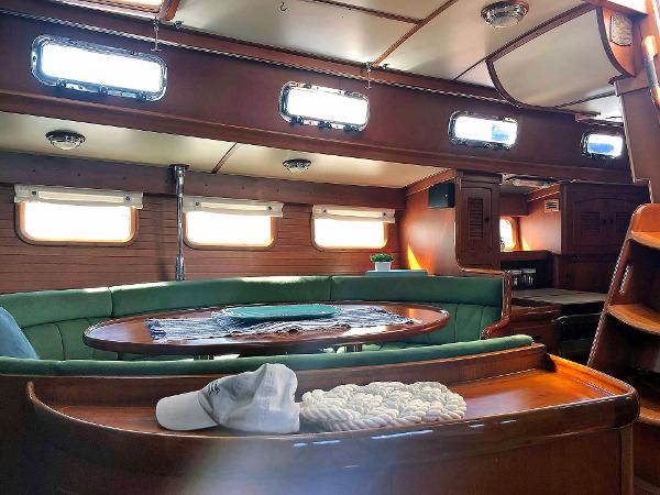 Interior of a 1988 Little Harbor 53 yacht with wood finish and green upholstery.