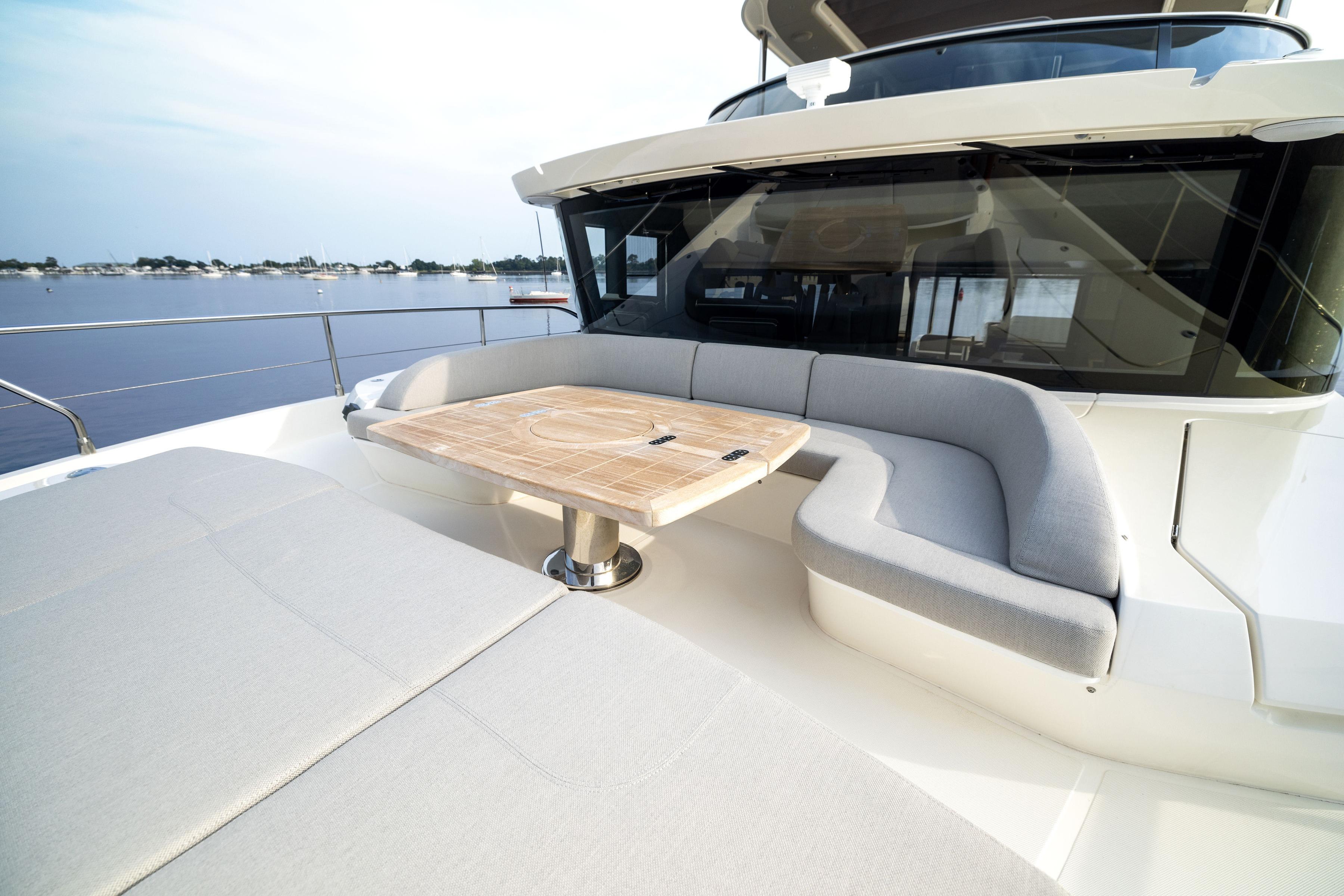 Luxurious 2024 Absolute Navetta 64 yacht with elegant outdoor seating and table.