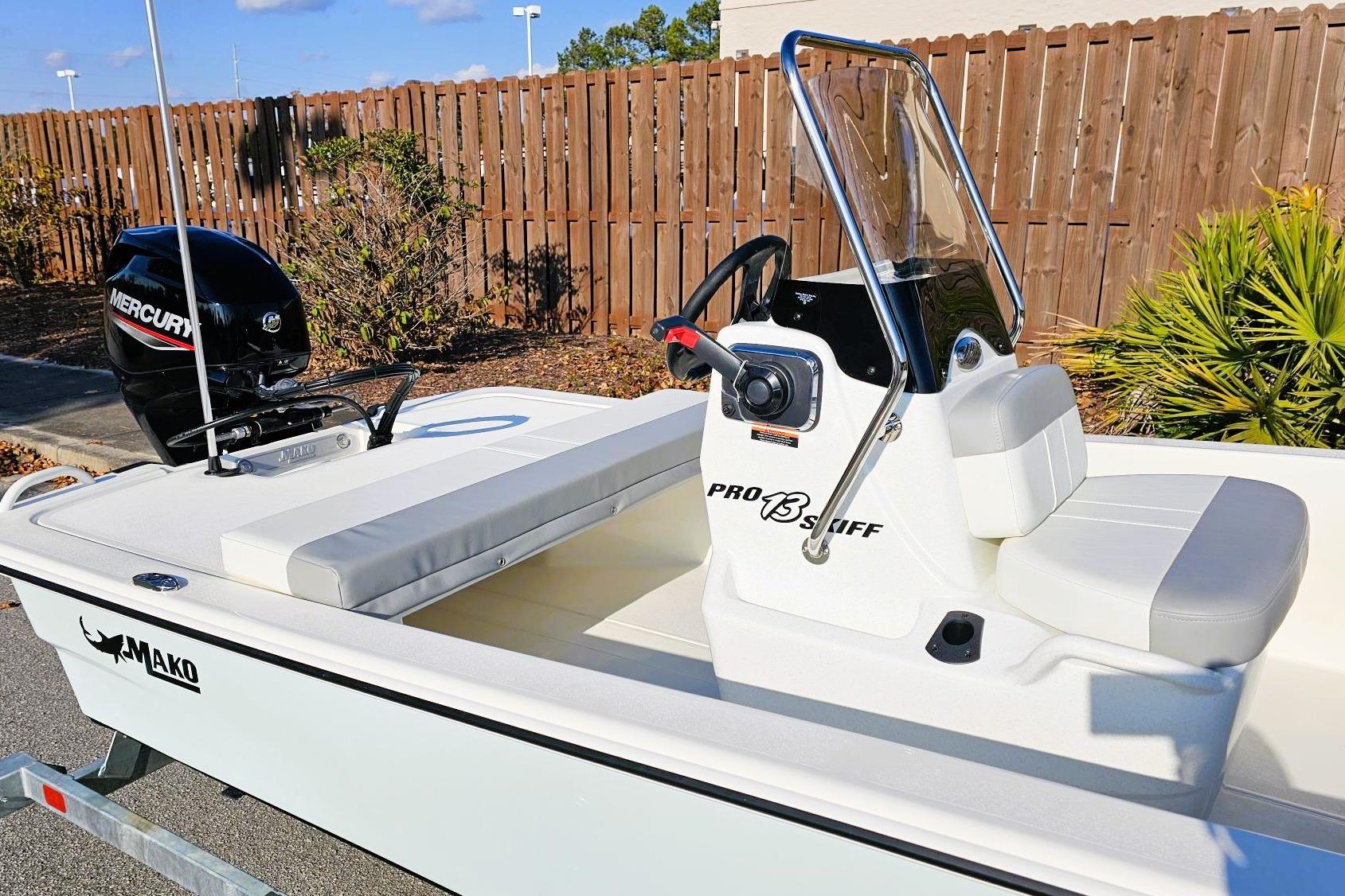 2026 Mako Pro Skiff 13 CC boat with Mercury engine, parked outdoors.