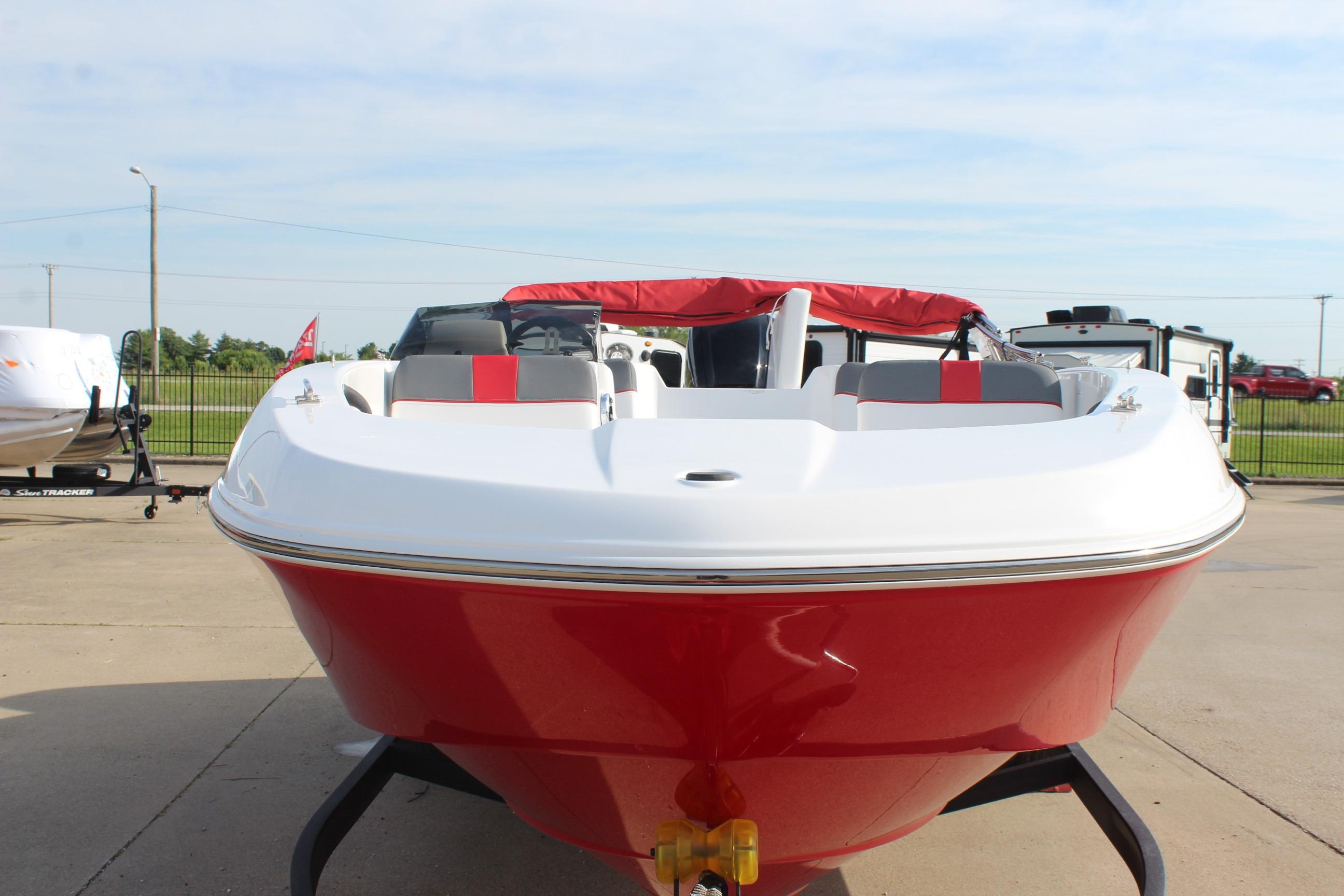 2026 Tahoe T18 boat, red and white, parked on a trailer outdoors.