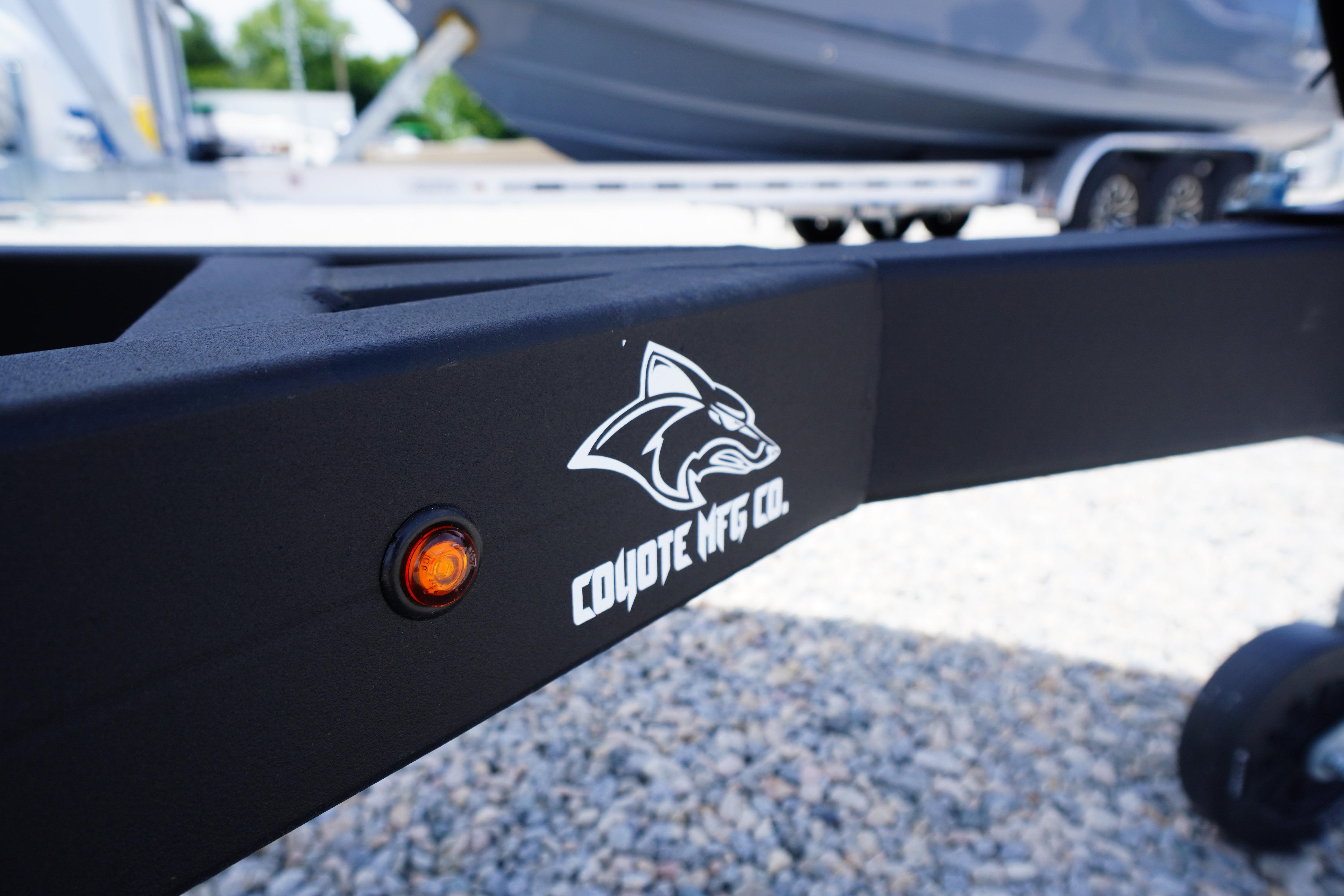 Trailer with Coyote MFG Co. logo, Chaparral 23 SSi OB boat in background.