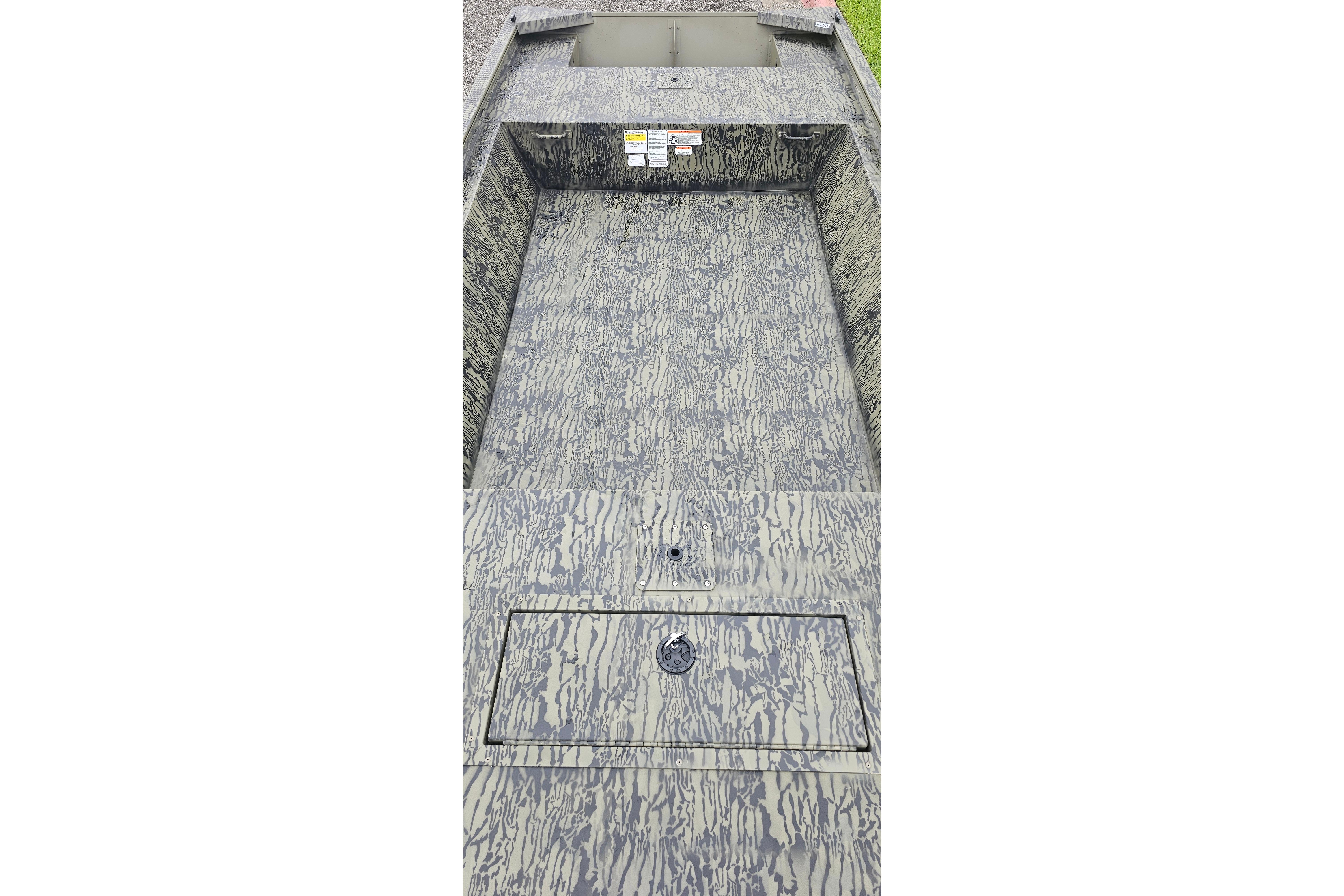 2026 Tracker Grizzly 1648 Utility boat interior with camouflage pattern flooring.