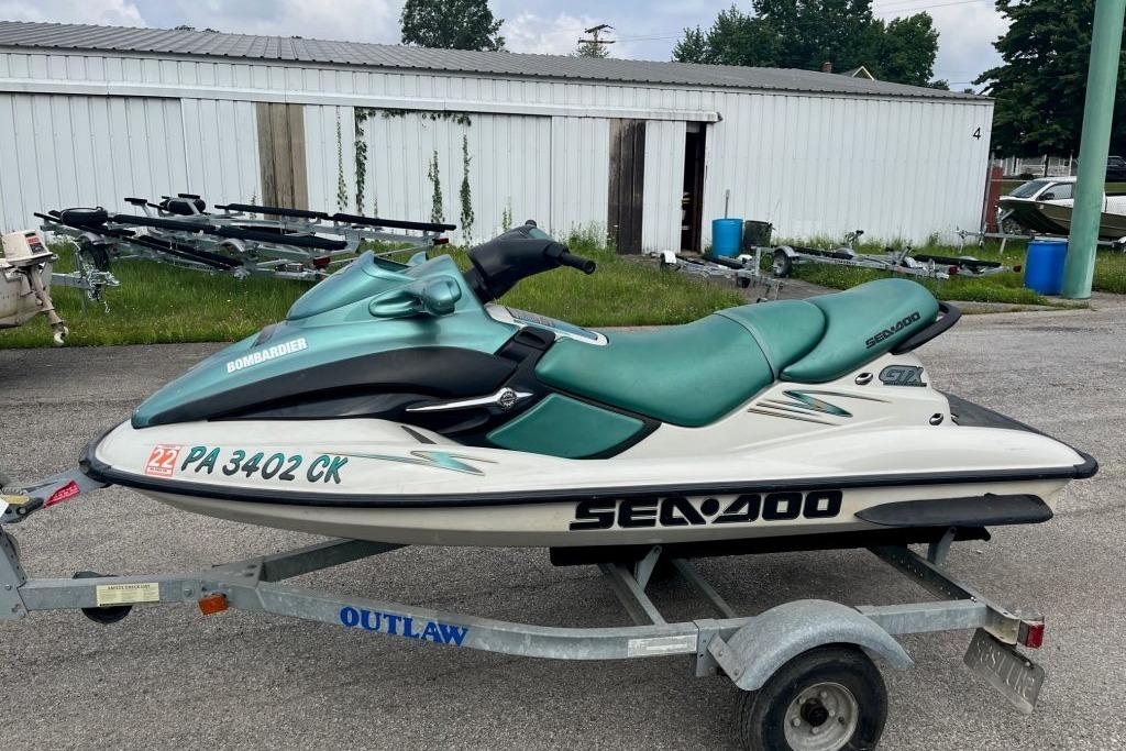 2001 Sea-Doo GTX jet ski on trailer, parked outdoors near storage units.