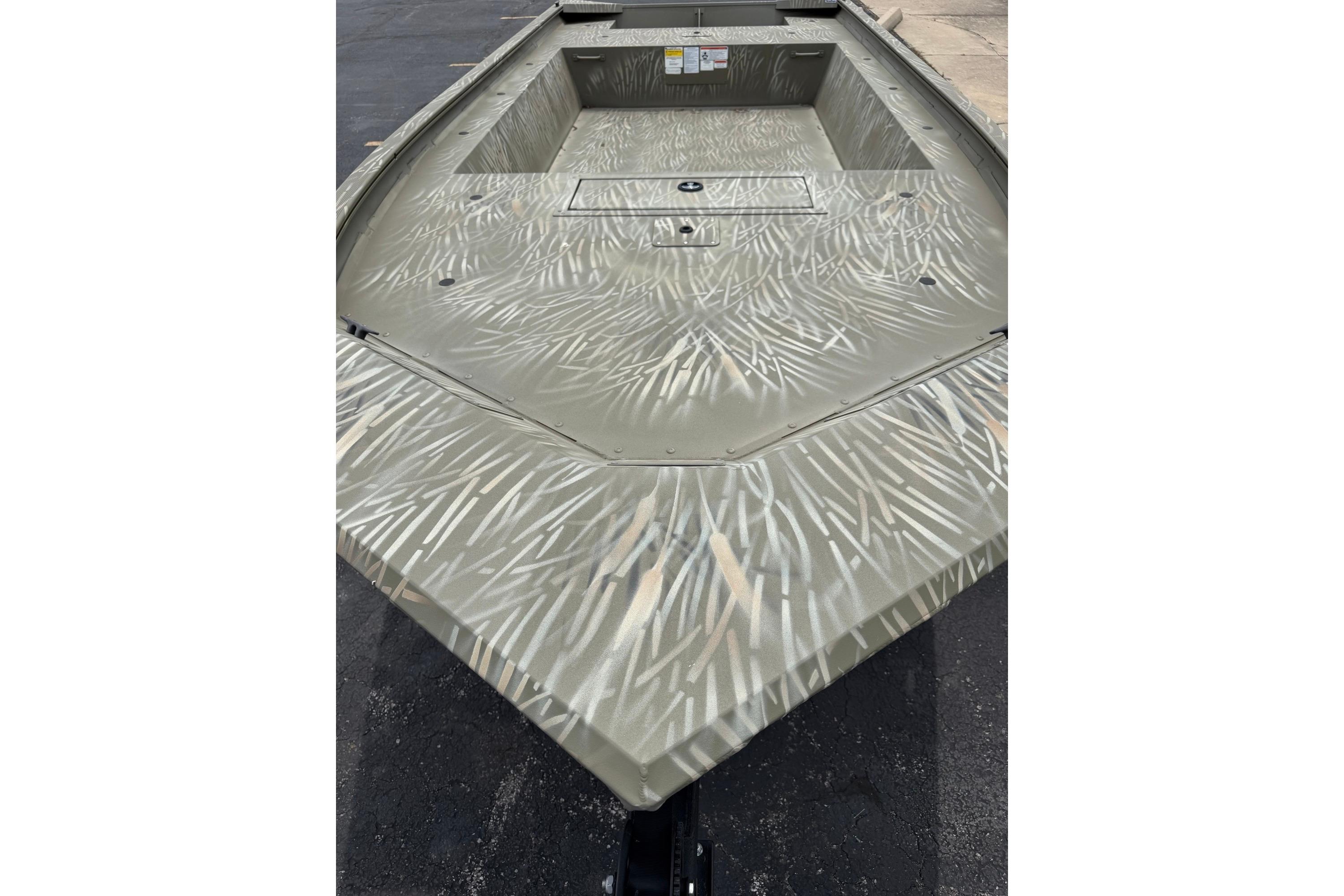 2025 Tracker Grizzly 1754 Jon boat with camouflage pattern on a paved surface.