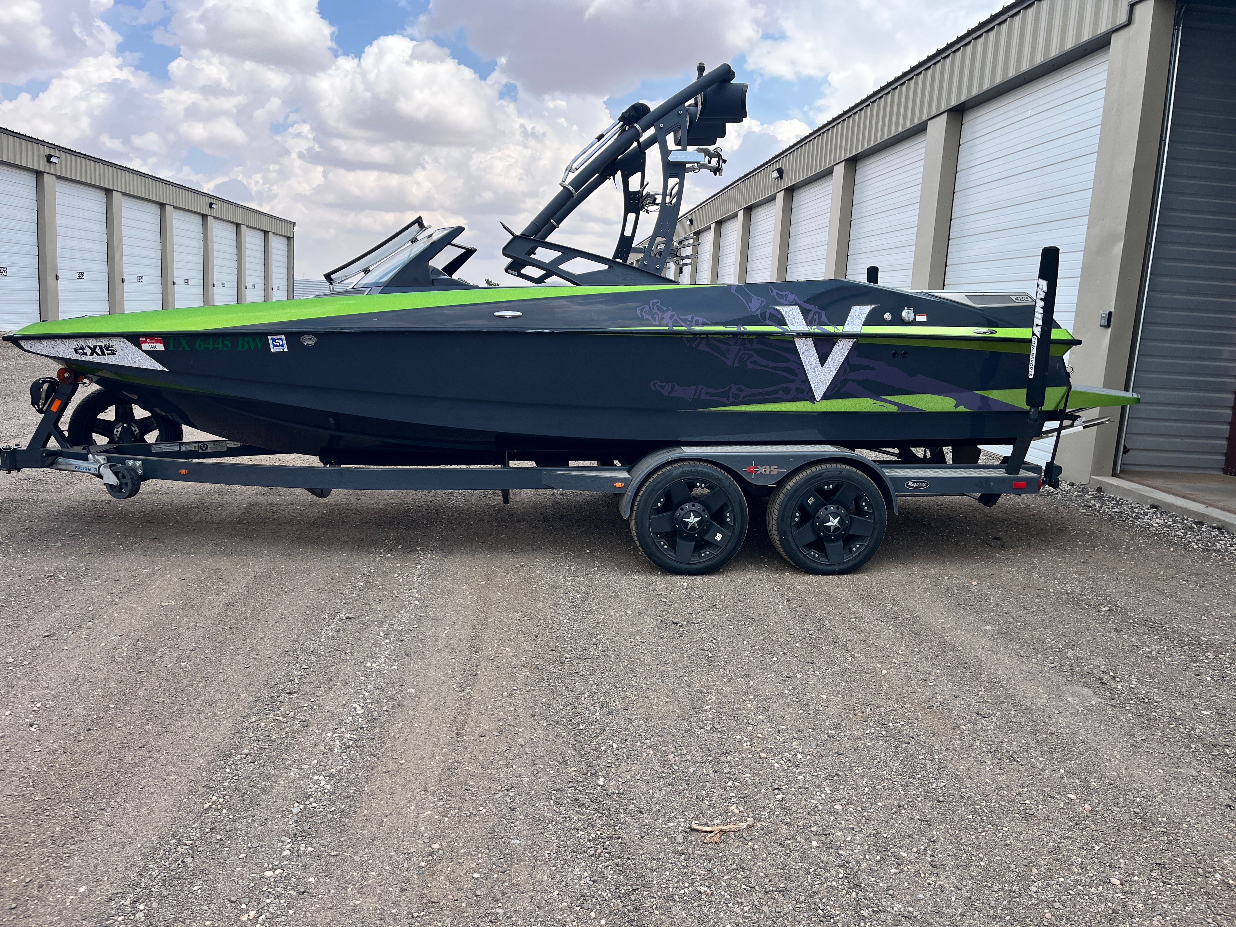 2013 Axis A22 boat on trailer in front of storage building.