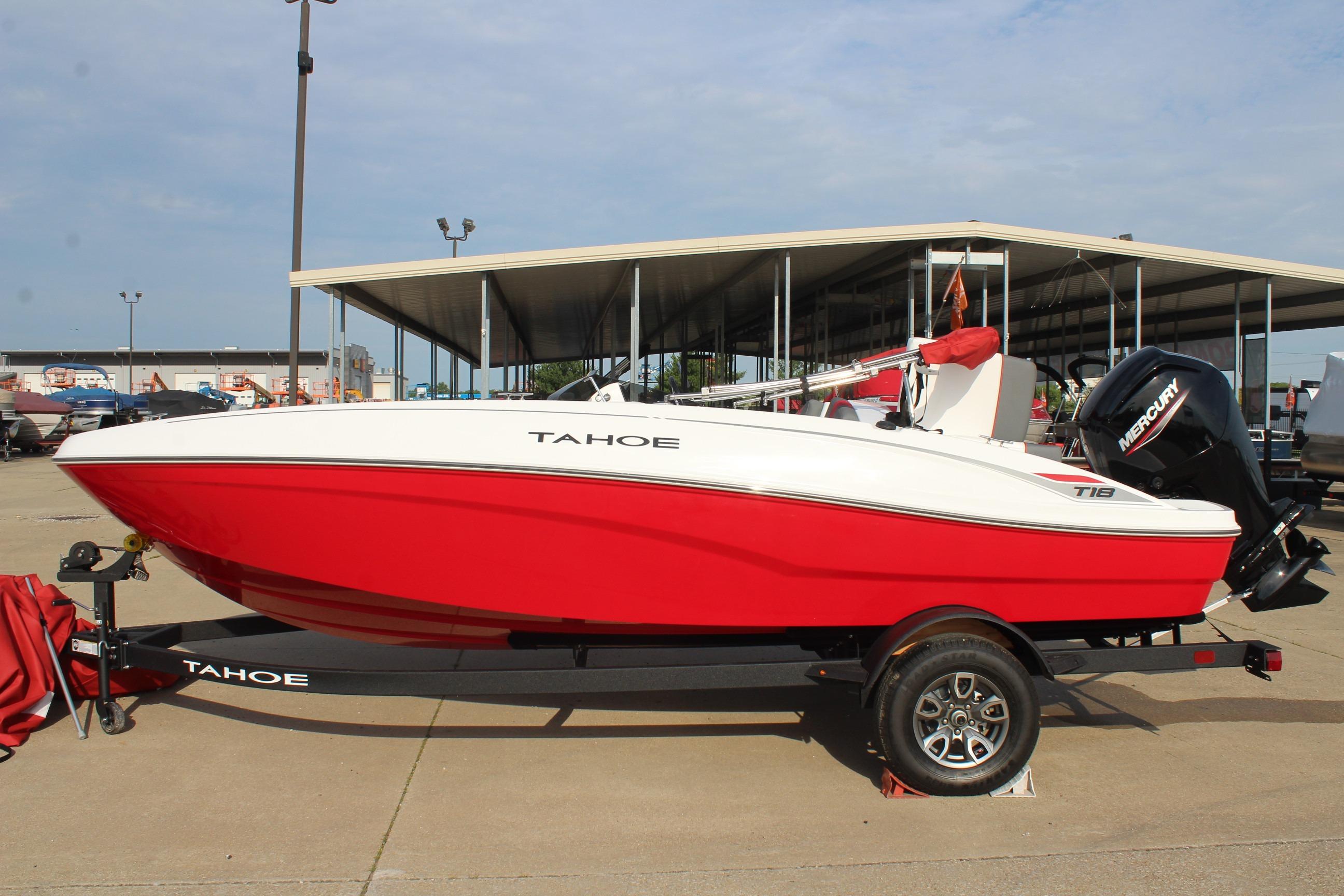 2026 Tahoe T18 boat in red and white, parked on a trailer at a marina.
