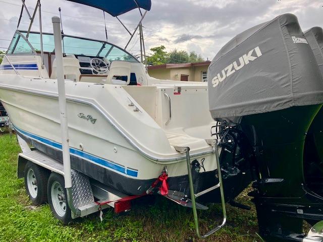 1990 Sea Ray 240 Sundeck boat on trailer with Suzuki outboard motor.