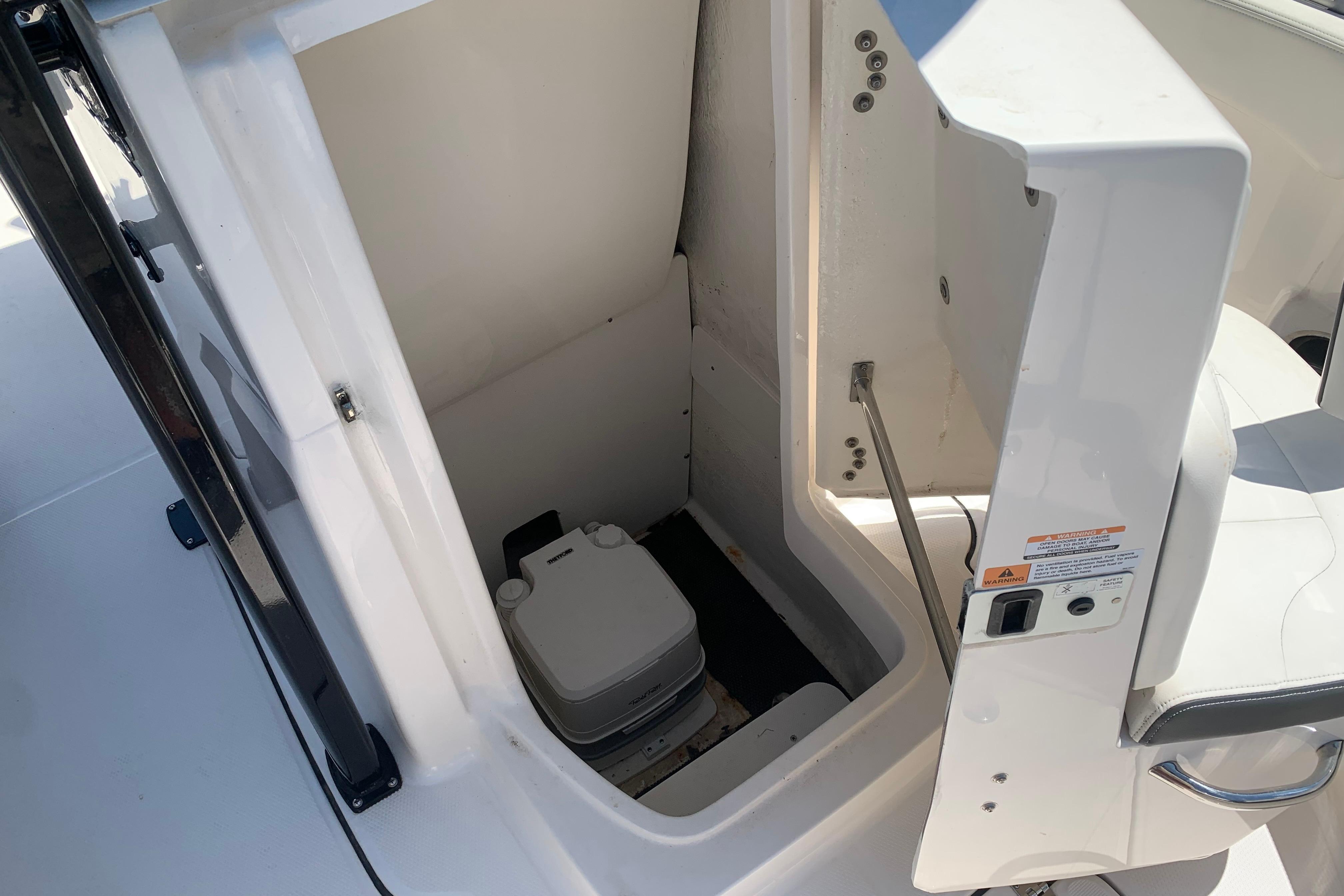 2023 Robalo R222 Center Console boat interior with compact marine toilet.