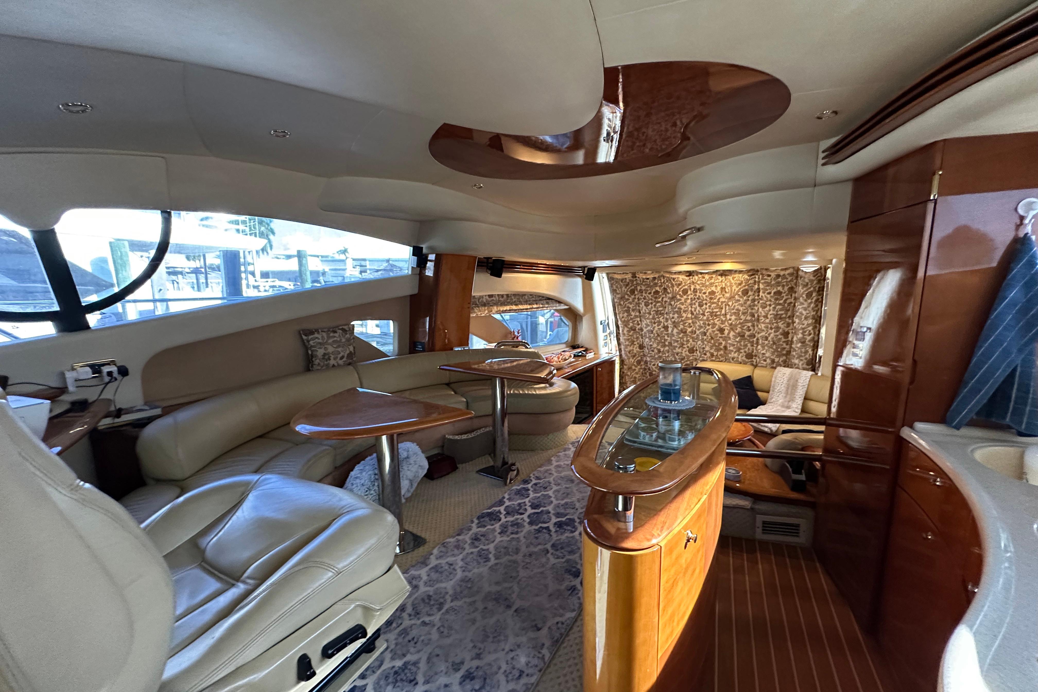 Luxurious interior of a 2004 Azimut 55E yacht with elegant seating and wooden finishes.