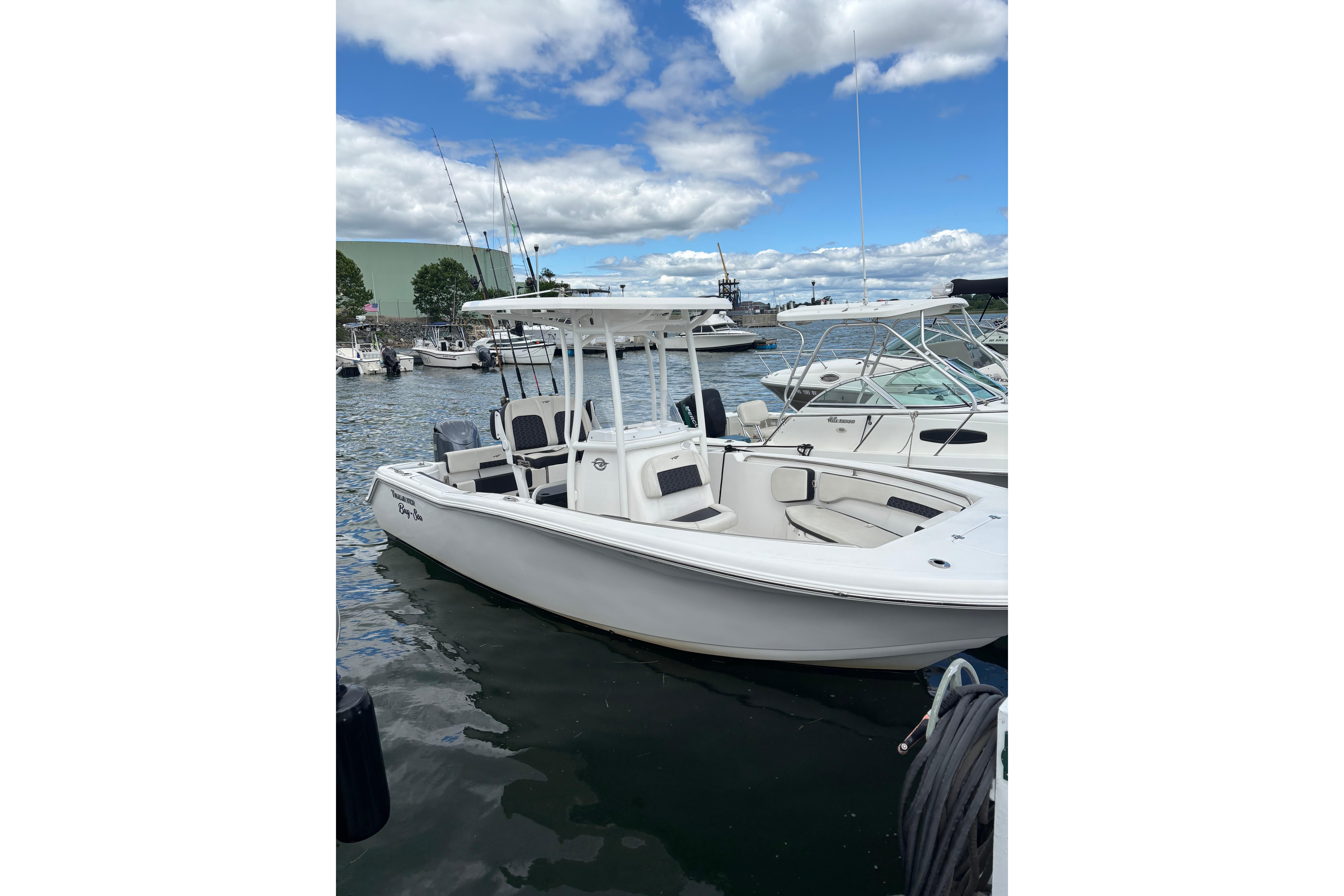 2024 Tidewater 220 CC Adventure boat docked in a marina under a partly cloudy sky.