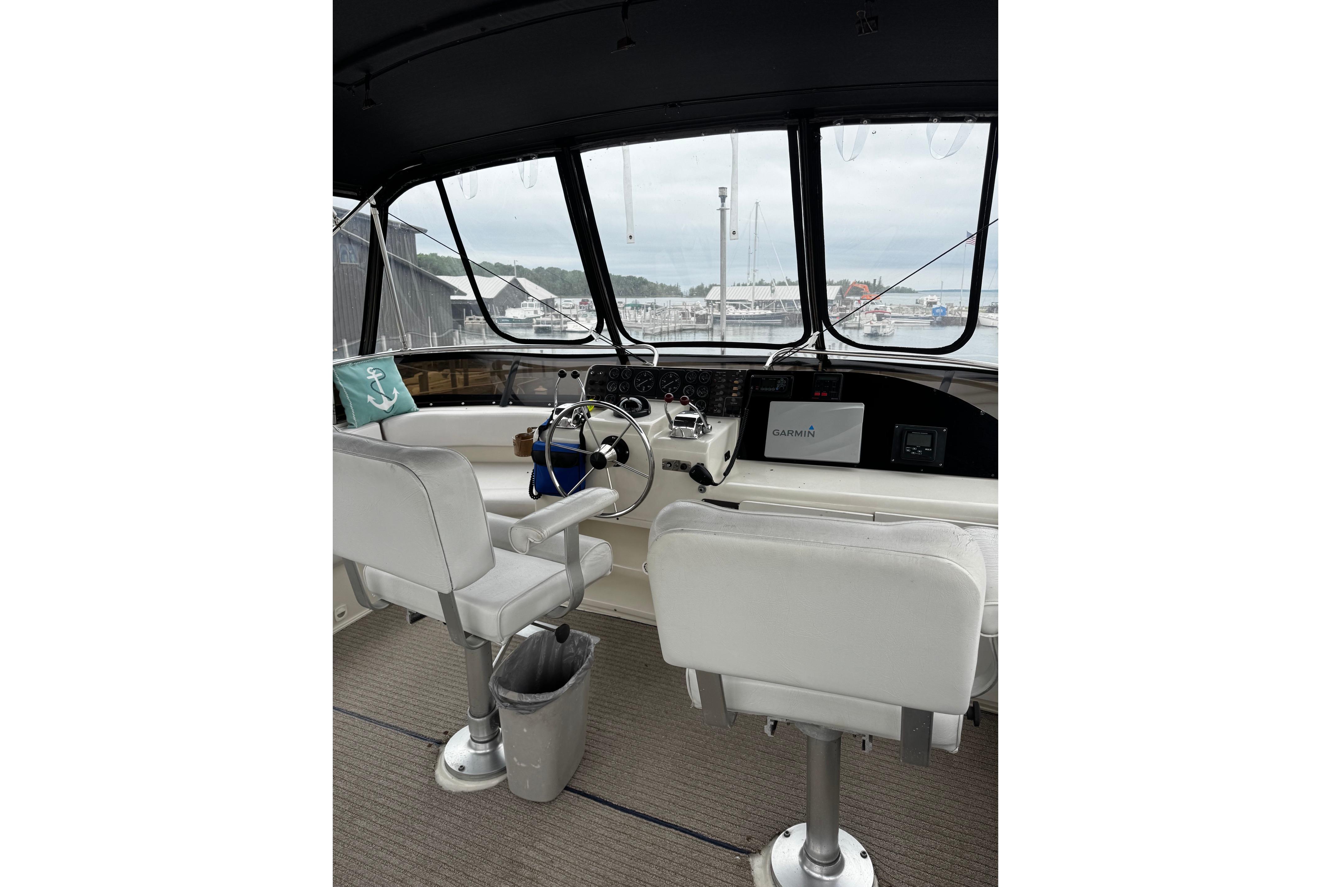Interior helm of 1991 Silverton 46 Motor Yacht with steering wheel and navigation equipment.