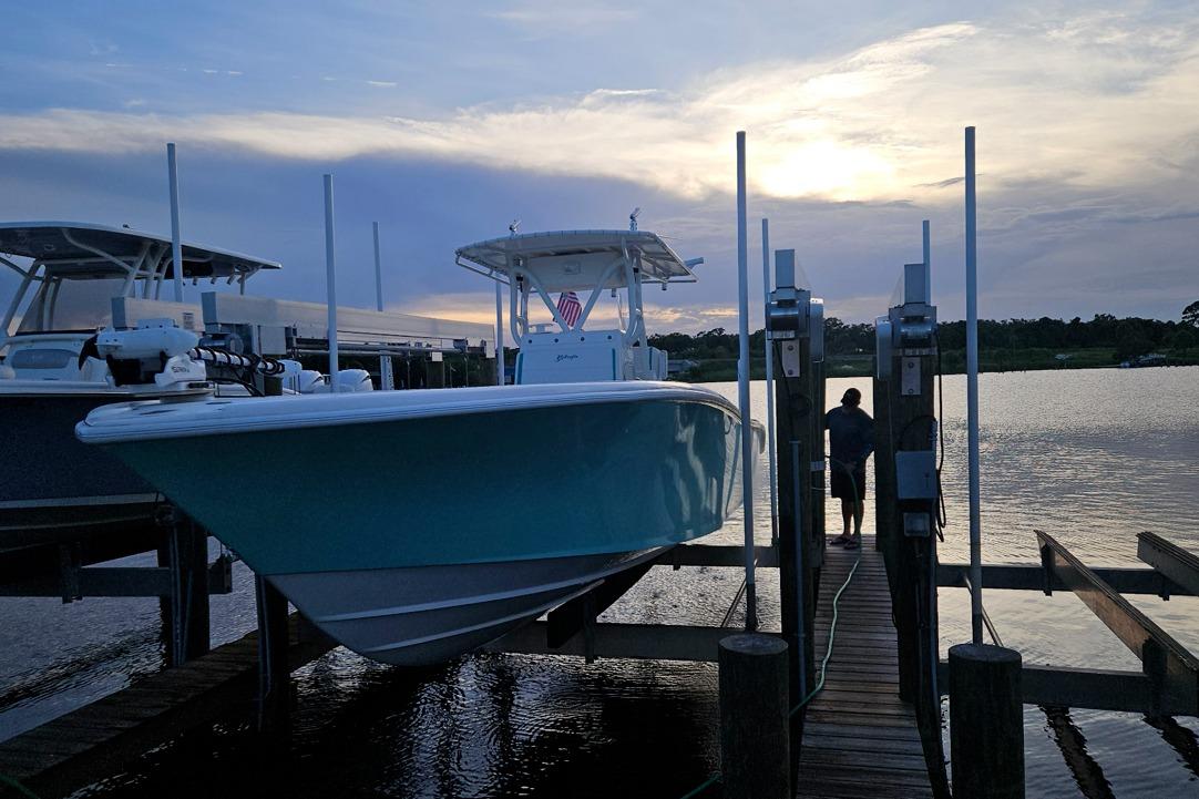 2002 Yellowfin 31 Center Console boat docked at sunset, calm waters.
