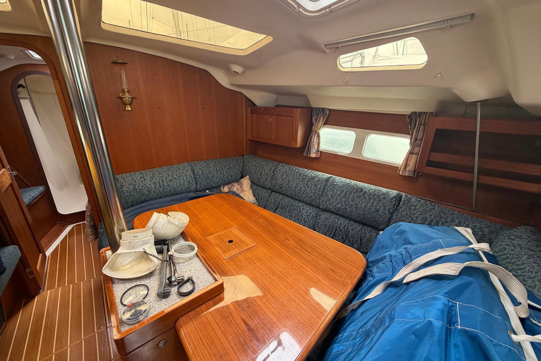 Interior of a 1998 Hunter 410 sailboat with cozy seating and wooden table.
