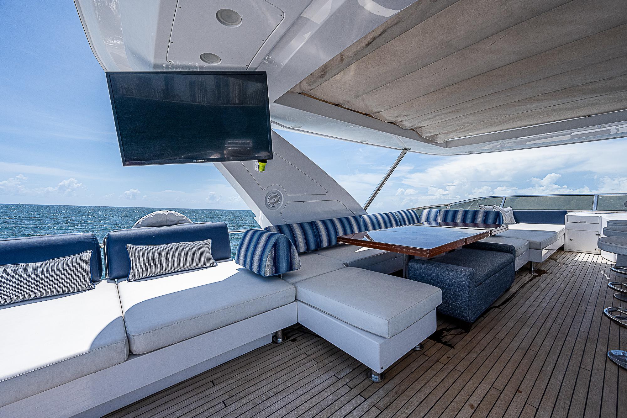 Luxurious 2011 Azimut 82 yacht deck with seating, TV, and ocean view.