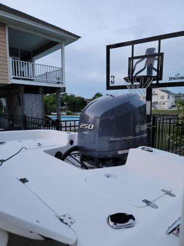 2011 Carolina Skiff 258 DLV with Yamaha 250 engine near a basketball hoop.