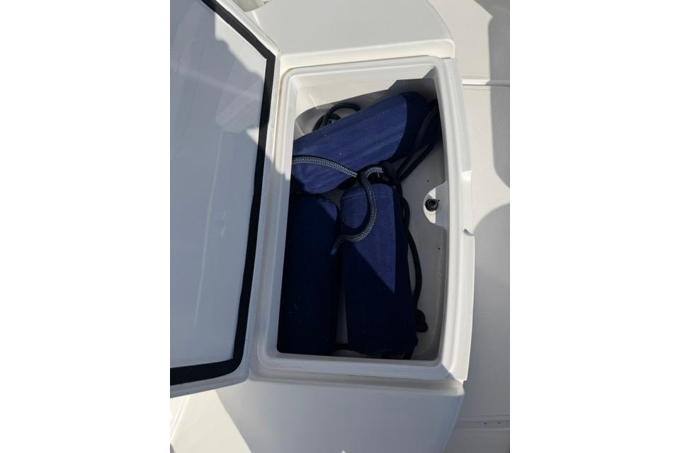 Storage compartment with blue life jackets on a 2014 Southport 29 FE boat.