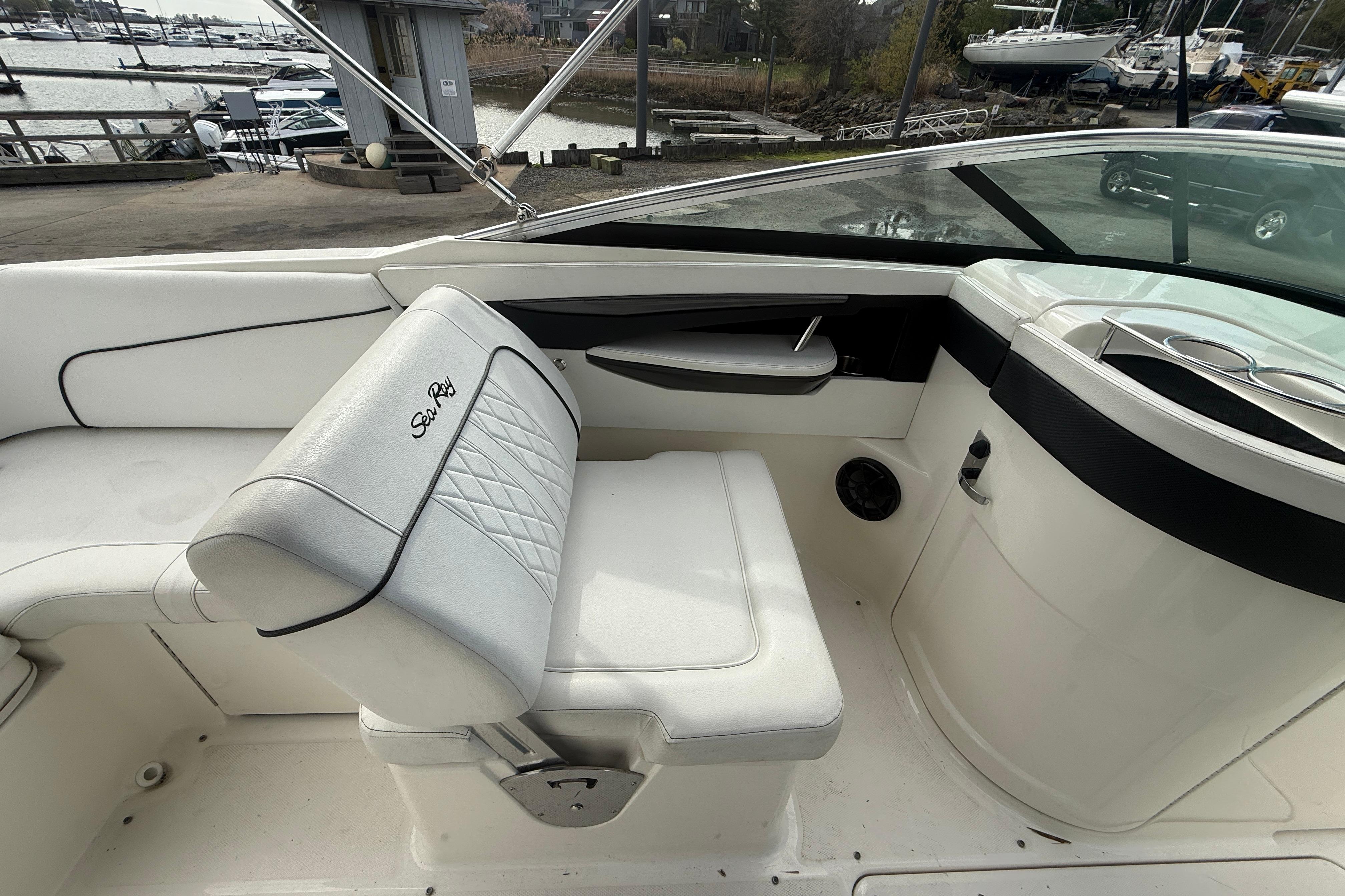 2015 Sea Ray 240 Sundeck interior with white seating and sleek dashboard design.