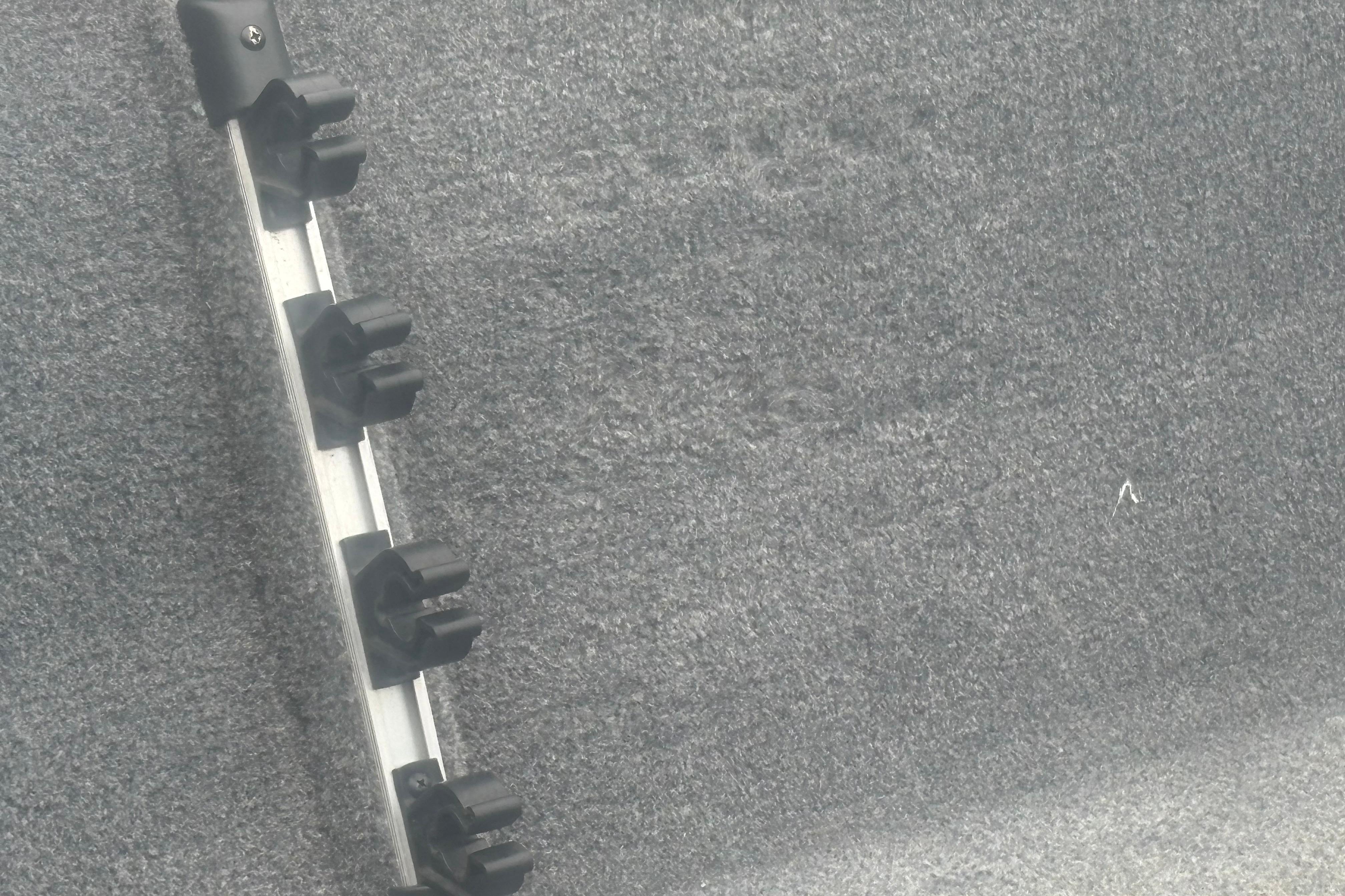 Rod holder on Bass Tracker III Classic 2020 boat, mounted on gray carpeted surface.